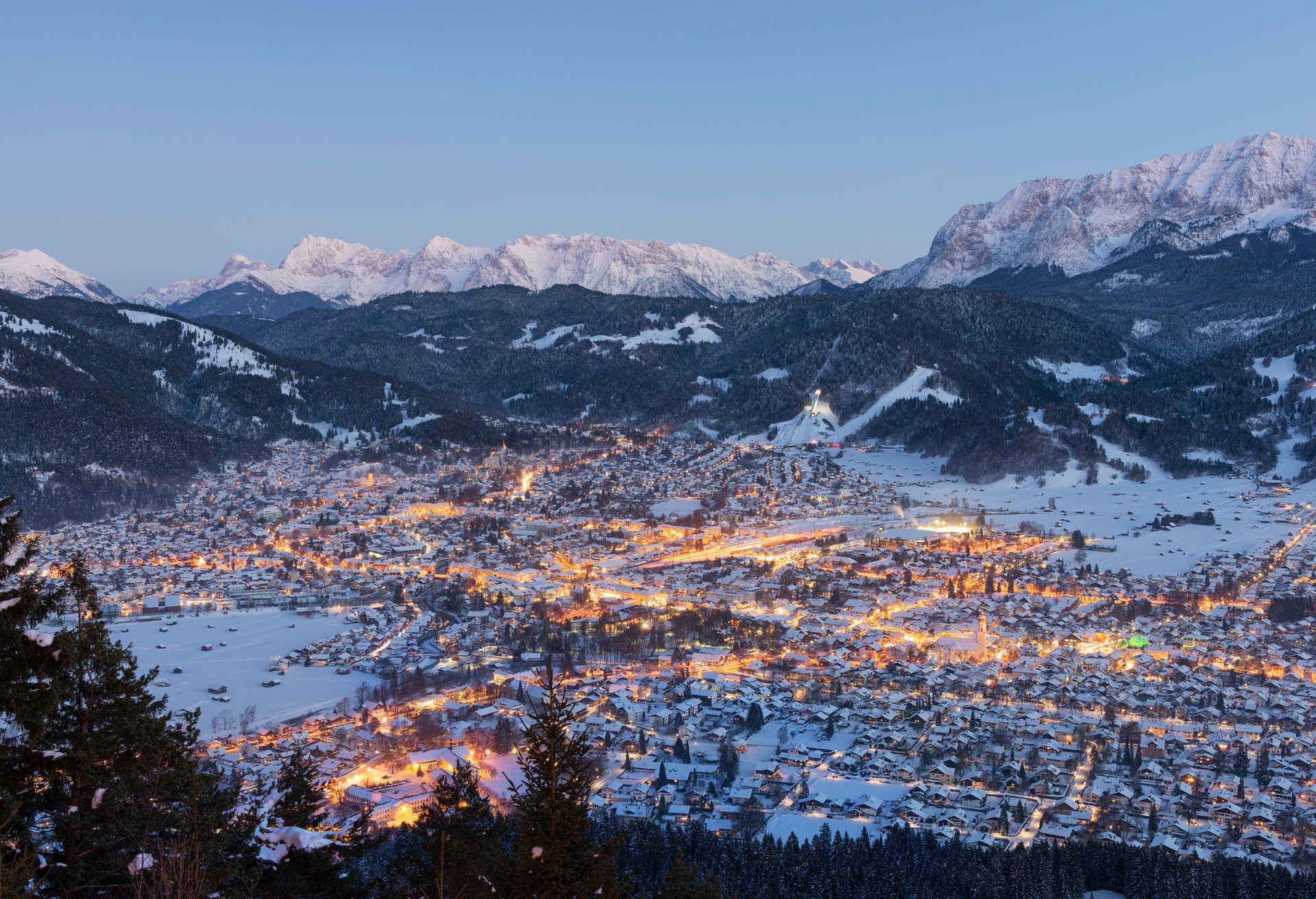 Garmisch-Partenkirchen with snow and mountains in the background at sunset, Bavaria, Germany; Shutterstock ID 561748624