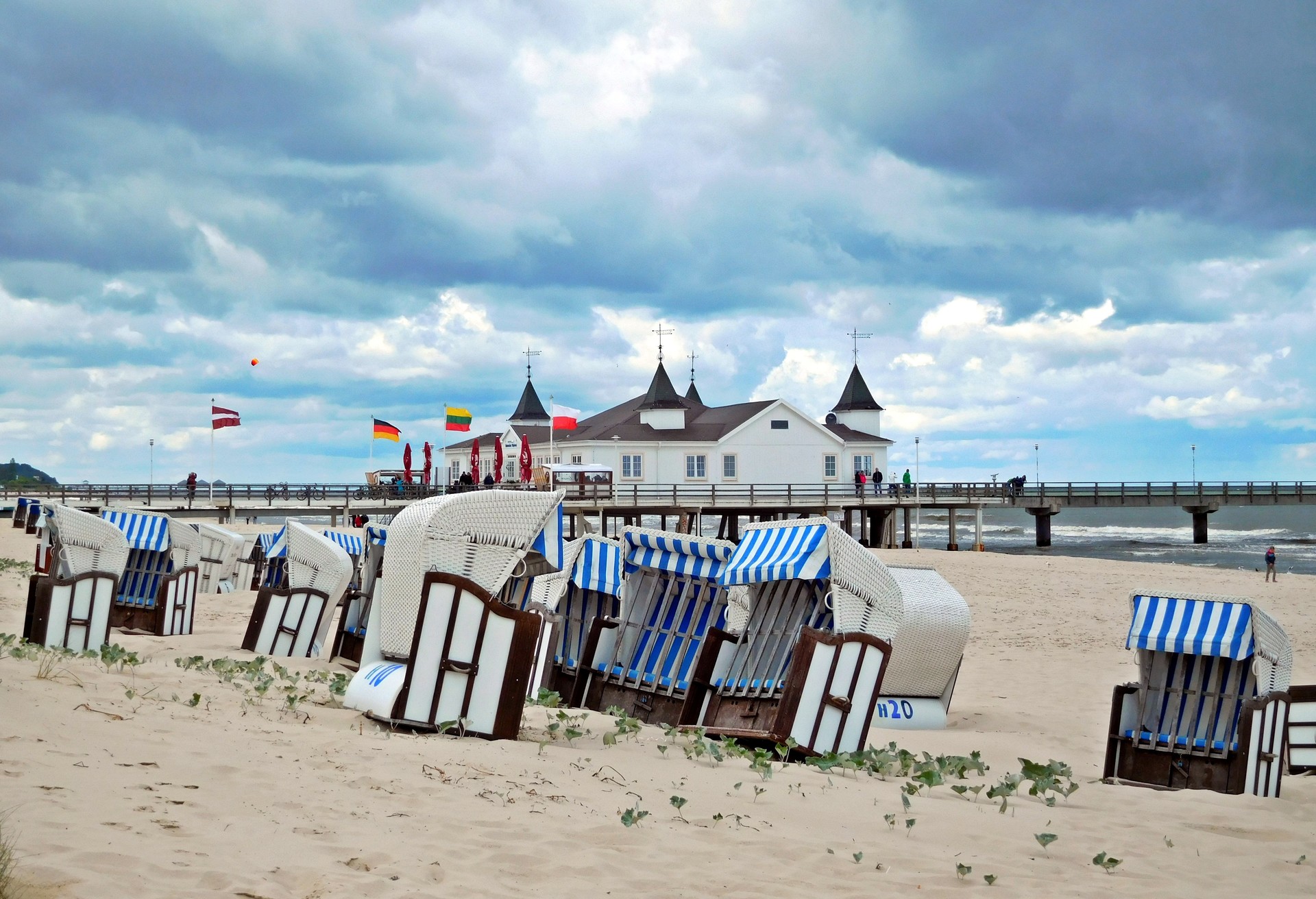 Beach of Ahlbeck. View of hooded beach chairs and the historic sea bridge.