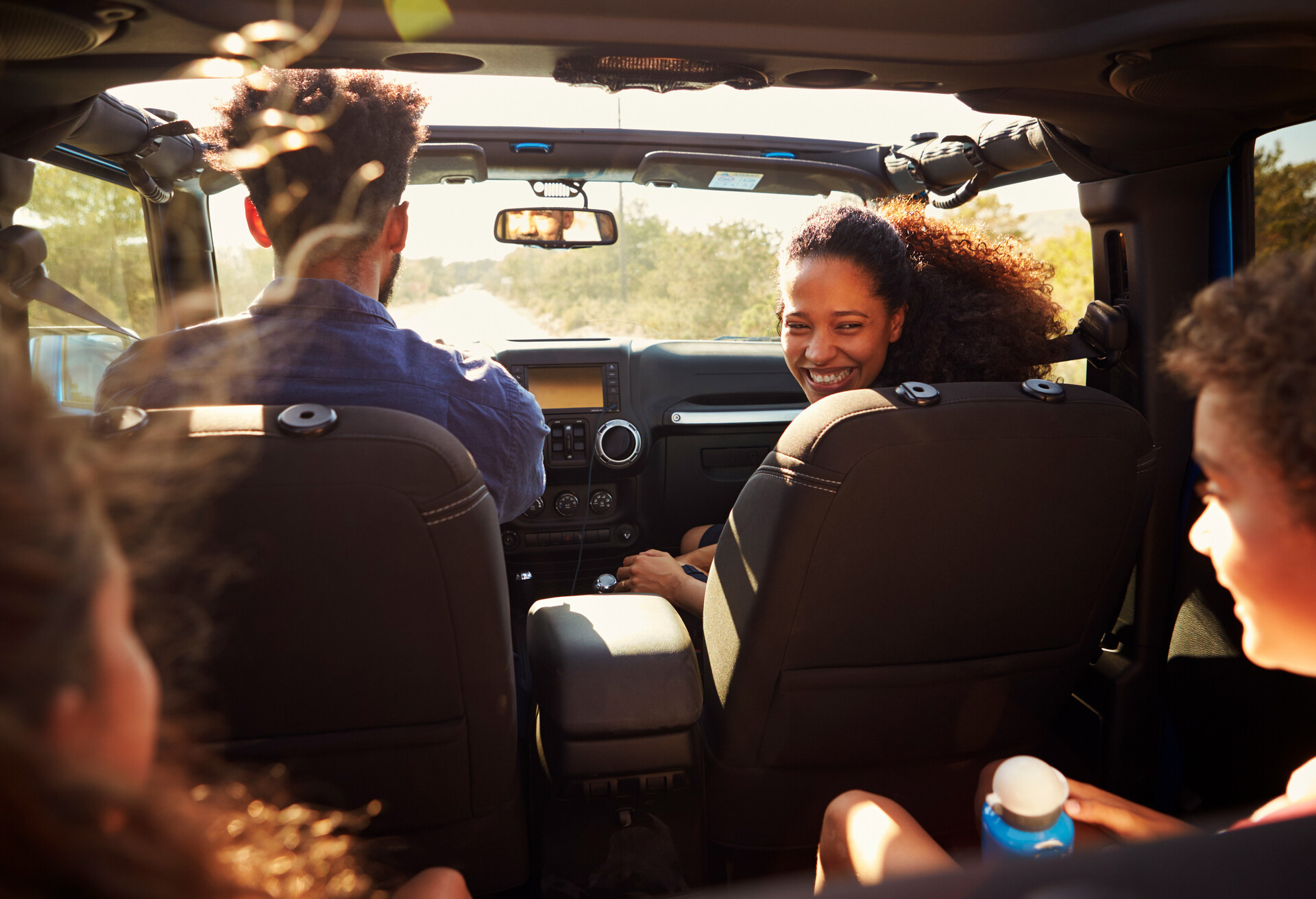 Excited family on a road trip in car, rear passenger POV; Shutterstock ID 560422282