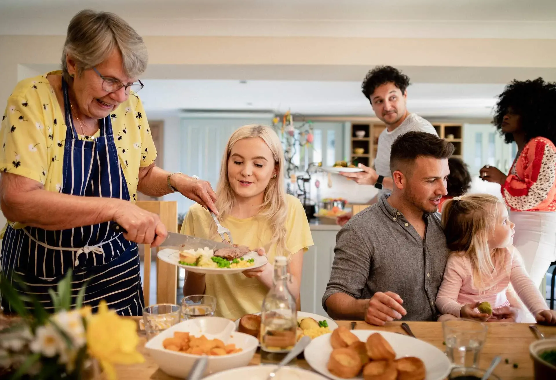 A front-view shot of a multi ethnic family ready to enjoy a roast dinner. 