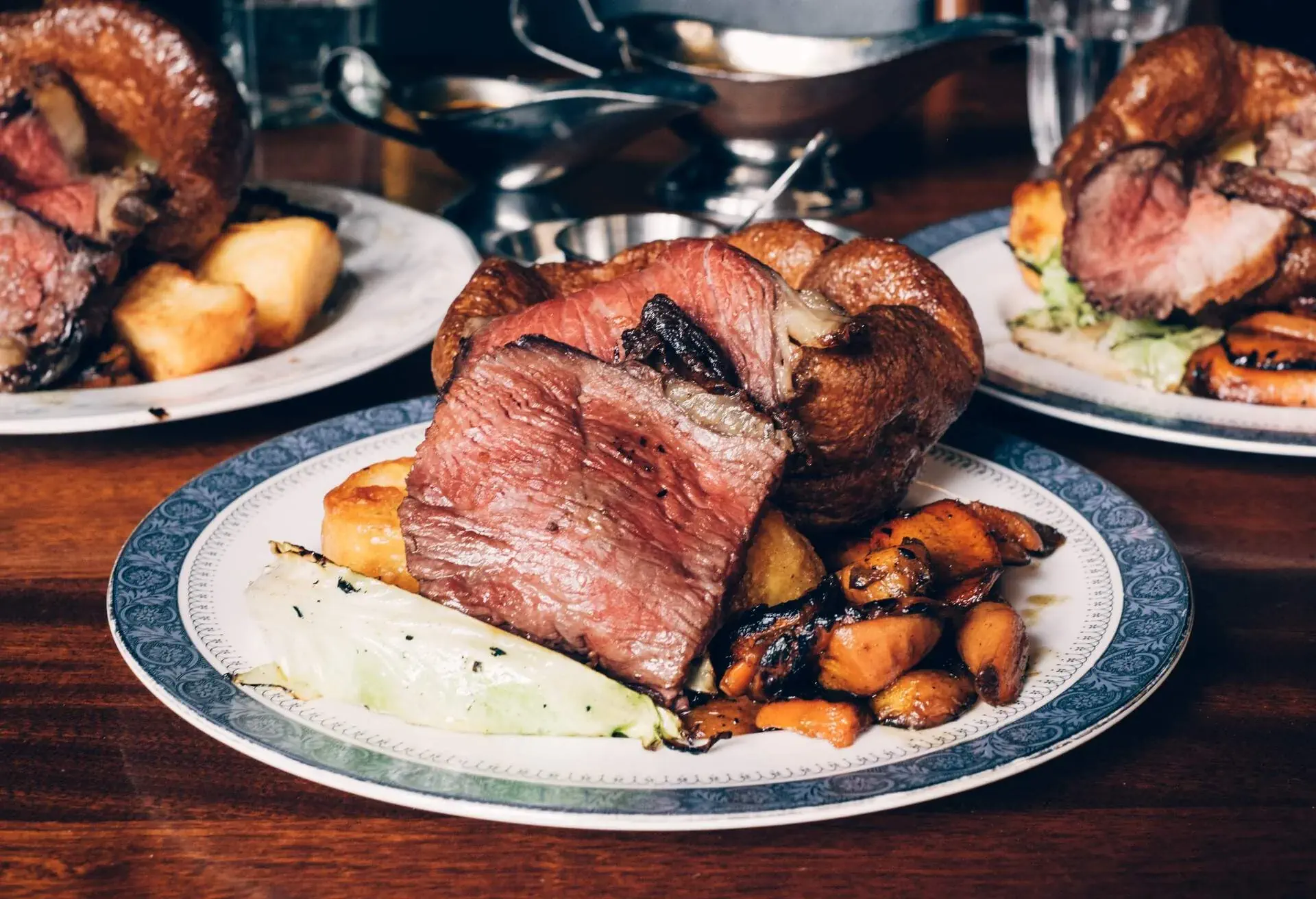 Traditional British Sunday roast dinner with beef, vegetables, gravy and a Yorkshire pudding. 