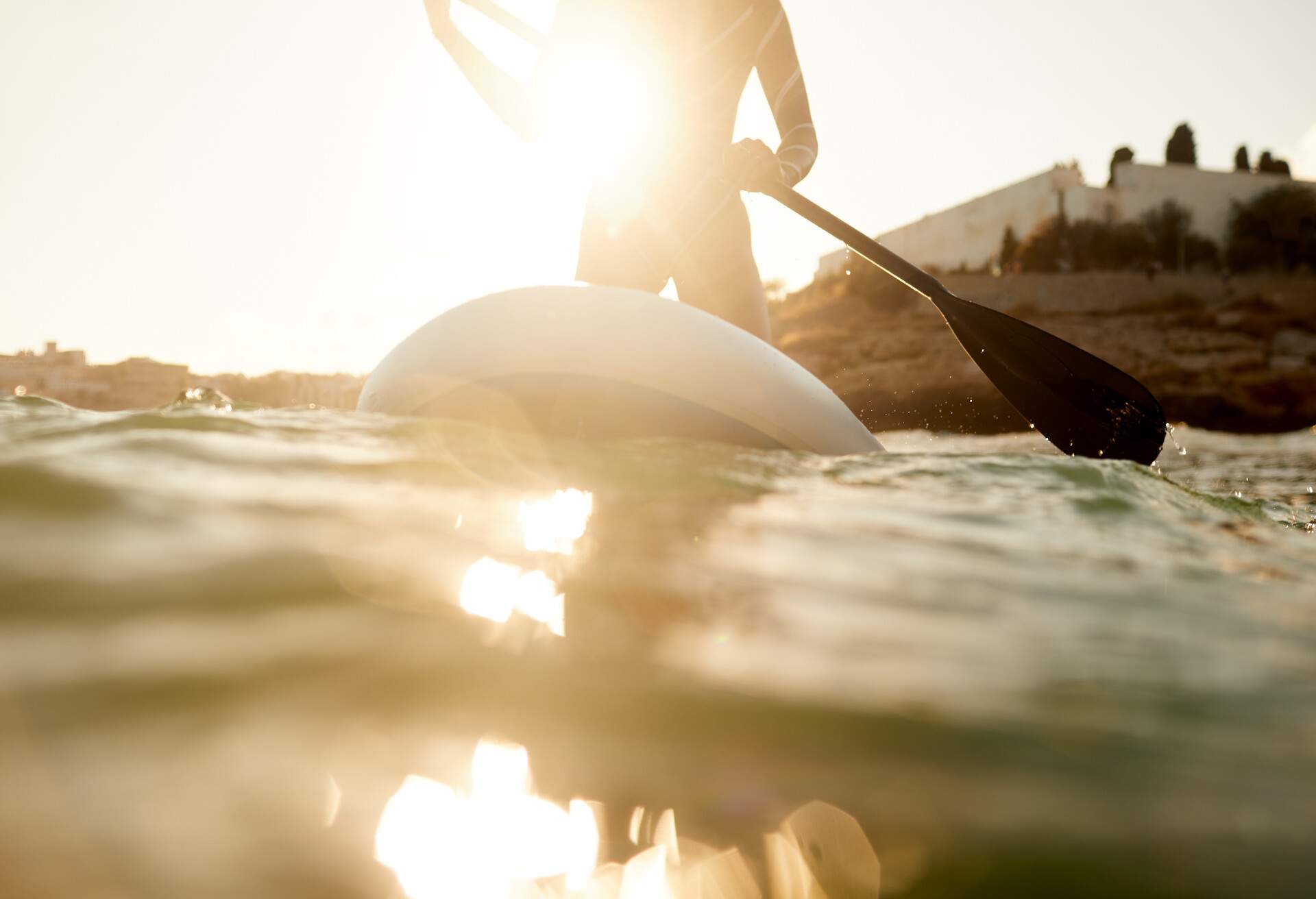 An unrecognizable person on her knees on a paddle surf.