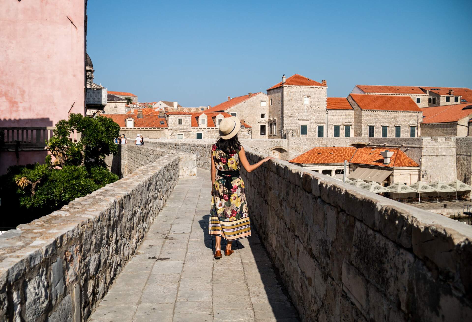 DEST_CROATIA_DUBROVNIK_Woman in Hat Walking Along a Section of the Walls of Dubrovnik_GettyImages-842442538