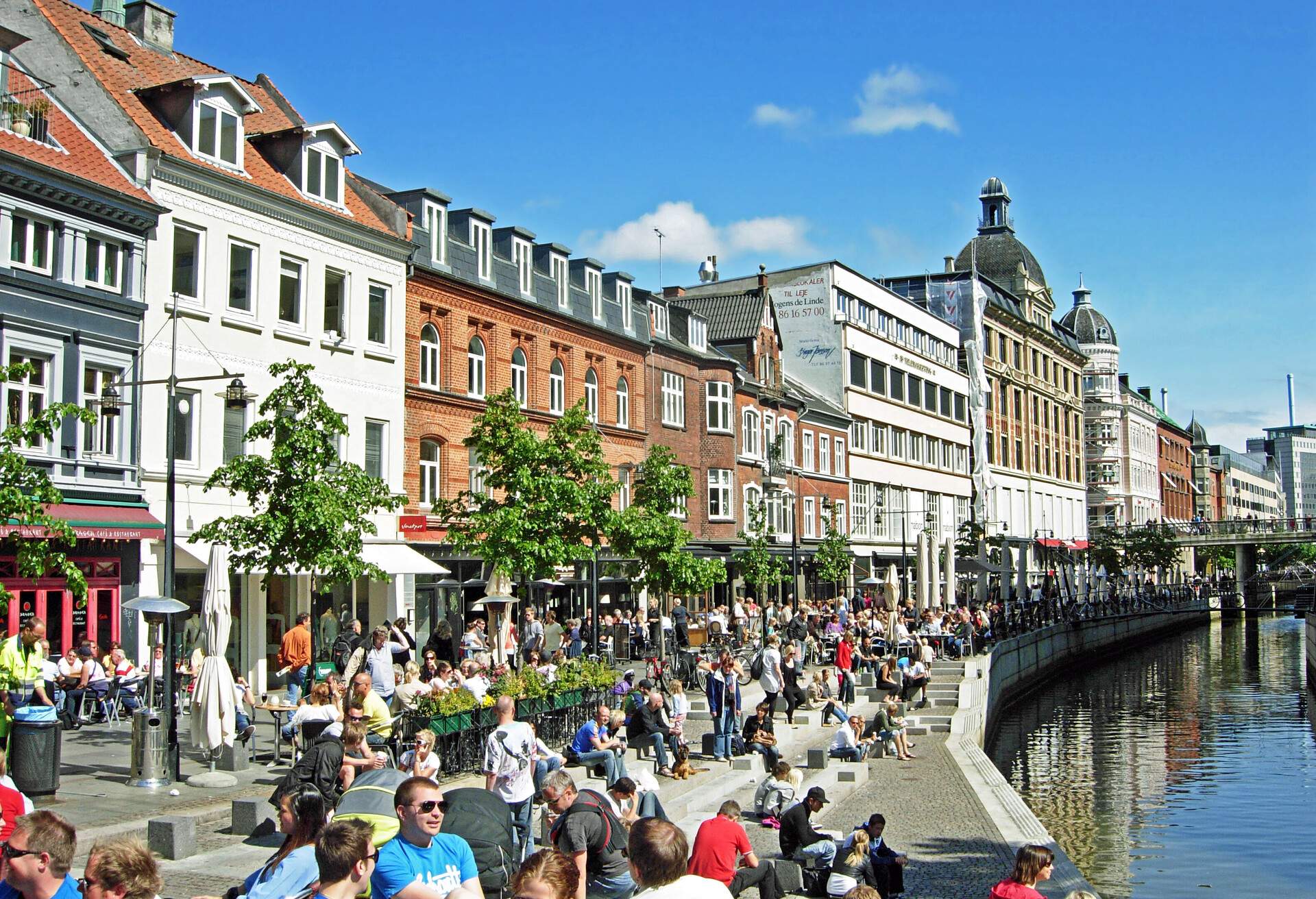 many people sitting at Aarhus Canal in the Midtbyen district 