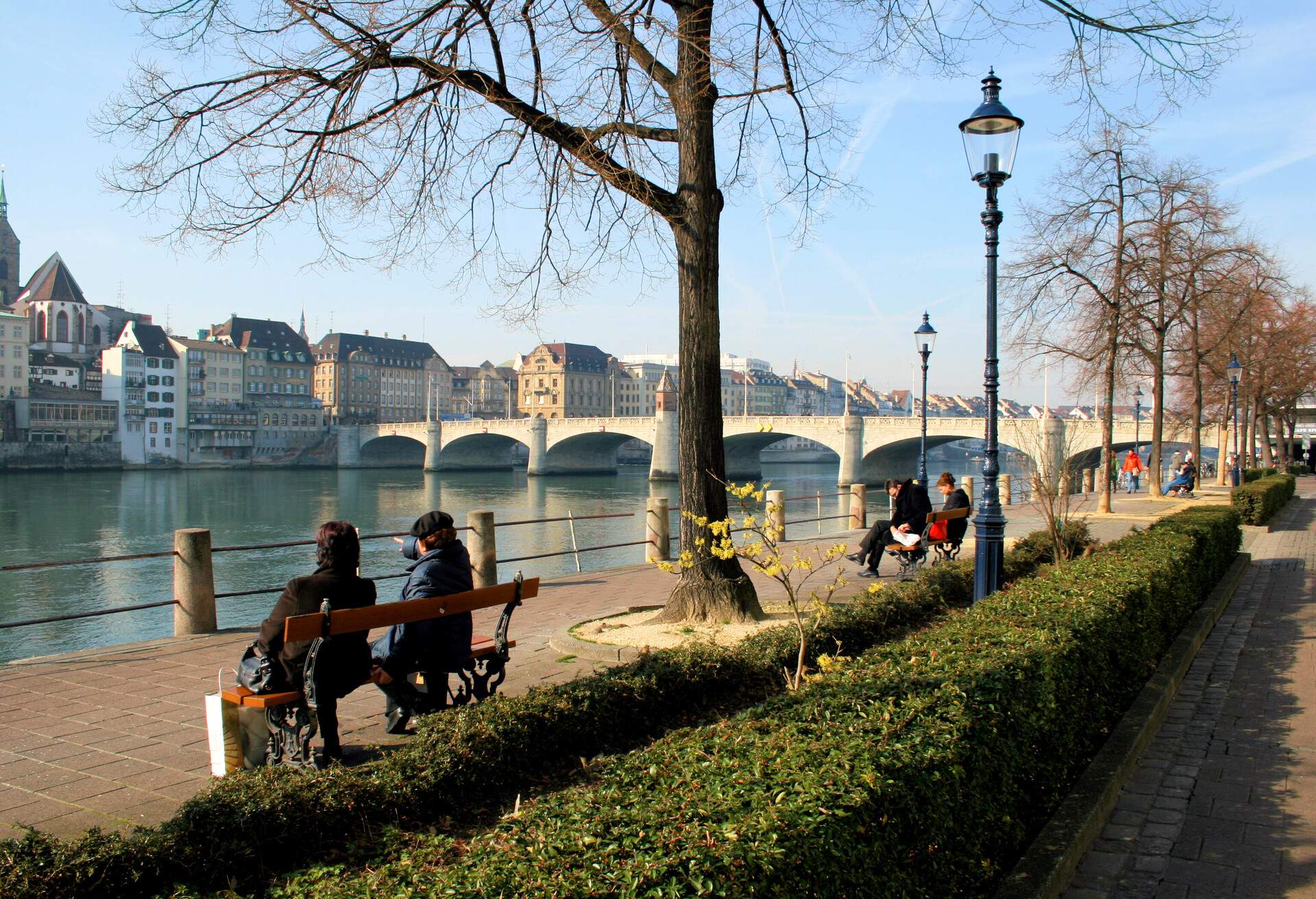 People relaxing on benches on a nice sunny afternoon in Basel / Switzerland. 