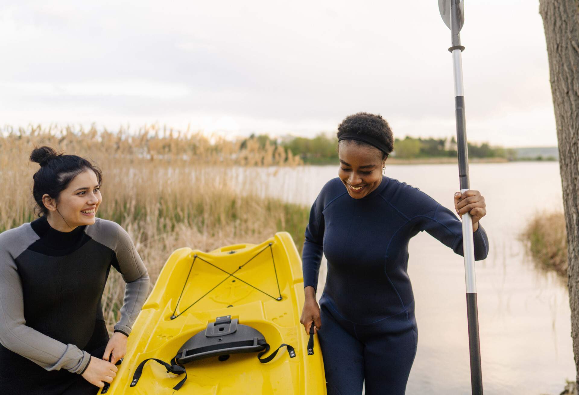 Photo of female friends getting ready to kayaking together.