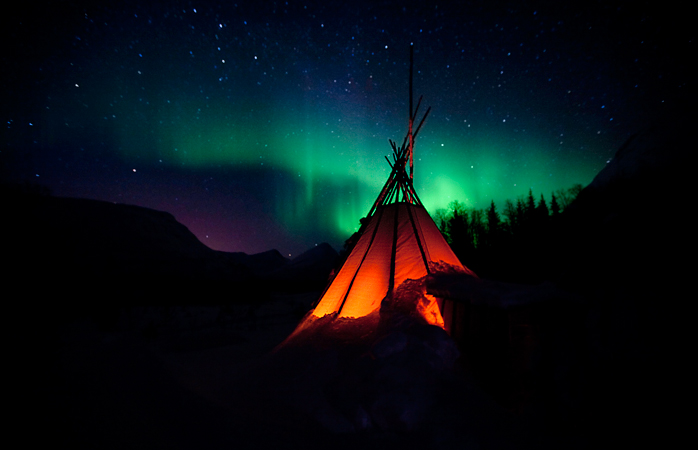 Ein typisch norwegisches Lavvo-Zelt unter der Aurora.