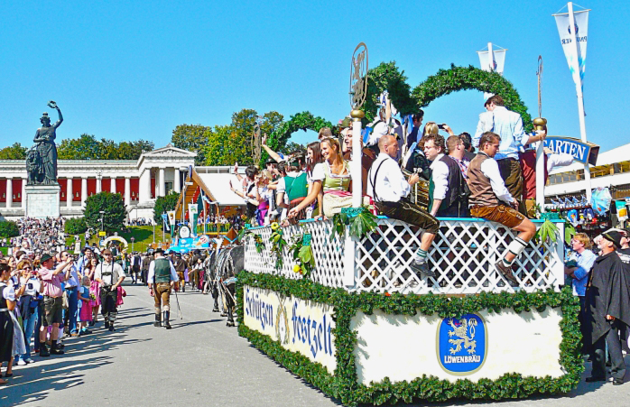 Eine ausgelassene Menge feiert die Eröffnung des Oktoberfestes vor der Statue der Bavaria.