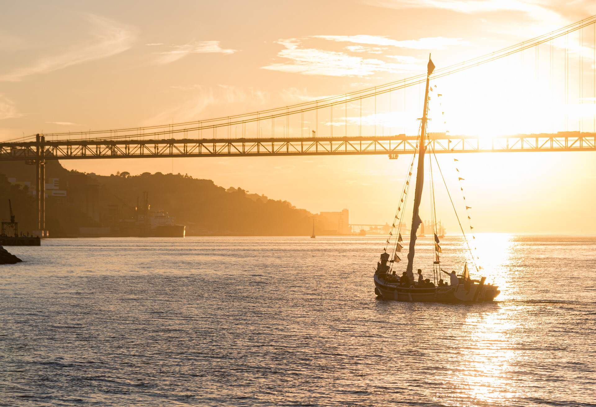 DEST_PORTUGAL_LISBON_BRIDGE_SUNSET_BOAT_GettyImages