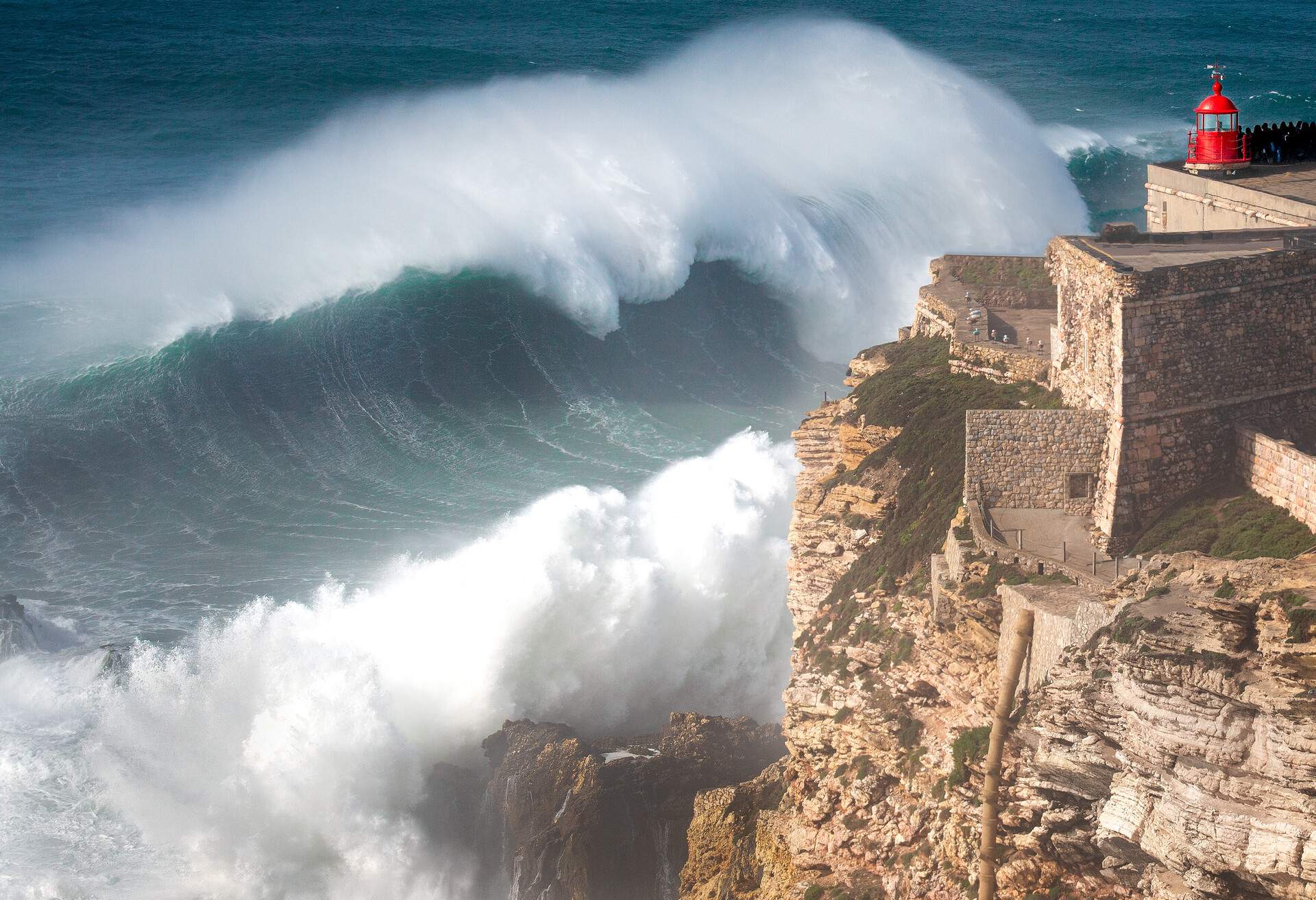 DEST_PORTUGAL_NAZARE_WAVES_AND_LIGHTHOUSE_GettyImages-1215353316