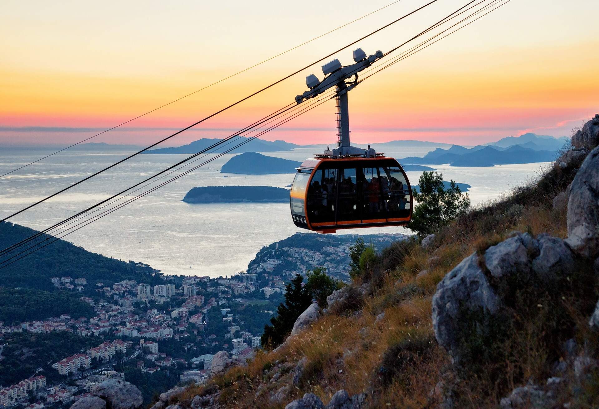 Cabin of cableway and ancient town of Dubrovnik at sunset on the background, Croatia