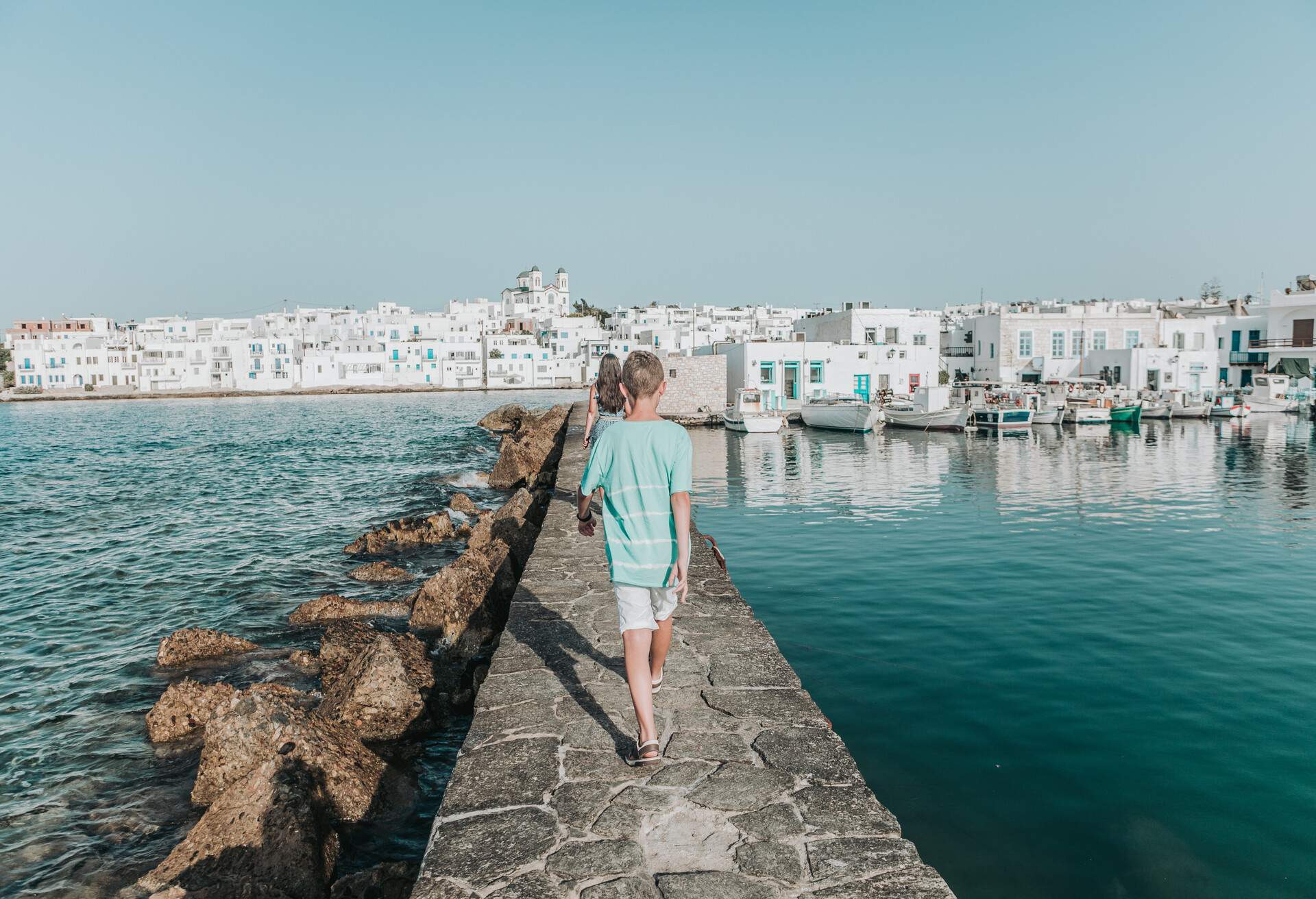 rear image of young travelers walking in Naoussa village,Paros,GREECE
