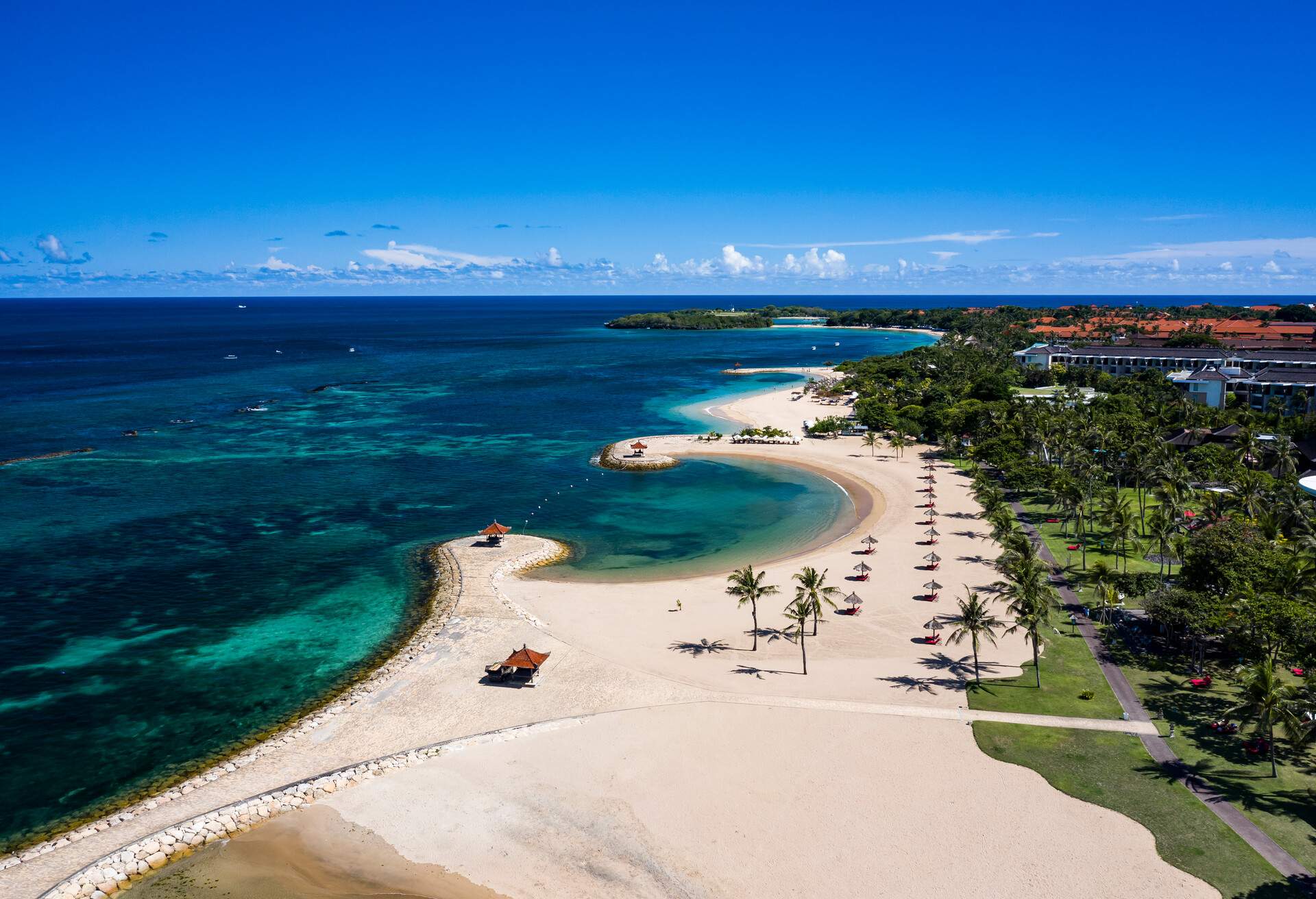 Aerial view taken by drone of the famous Nusa Dua resort hotel complex on the southern coast of Bali with white sand beach and clear blue lagoon