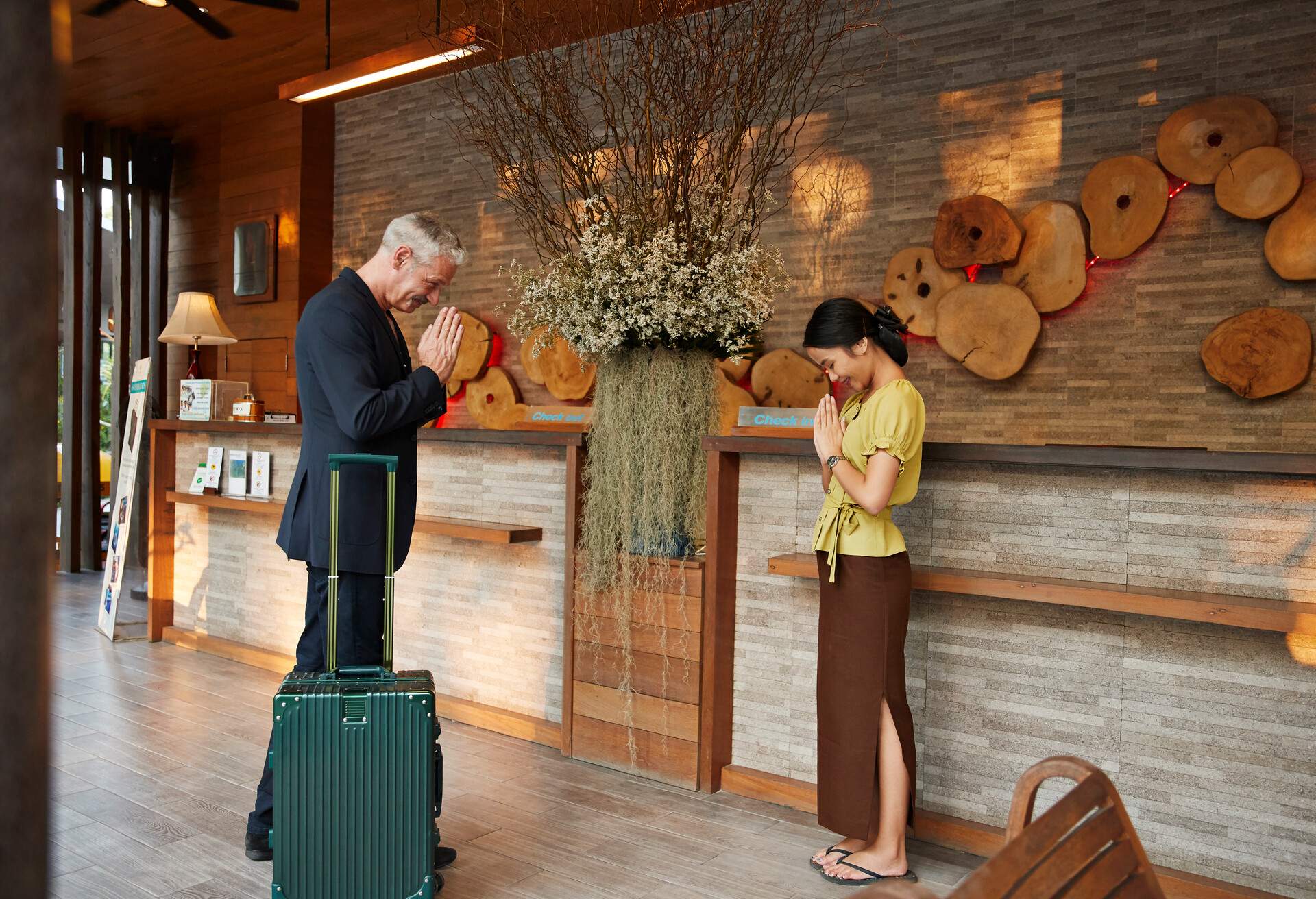 Male tourist greeting to female receptionist at resort counter