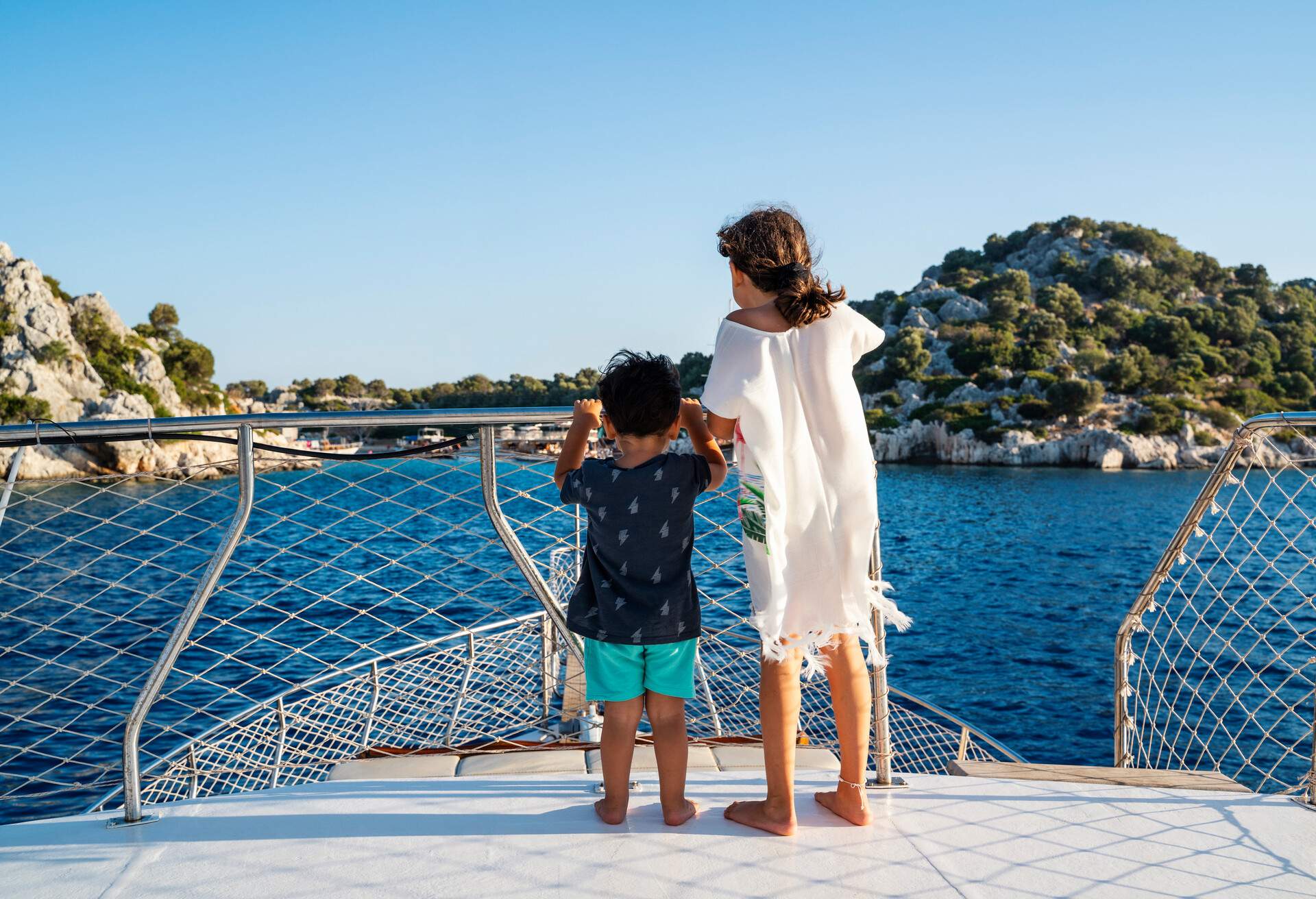 Cute little girl with her brother traveling on a sailboat at sunset in Kekova, Antalya, Turkey