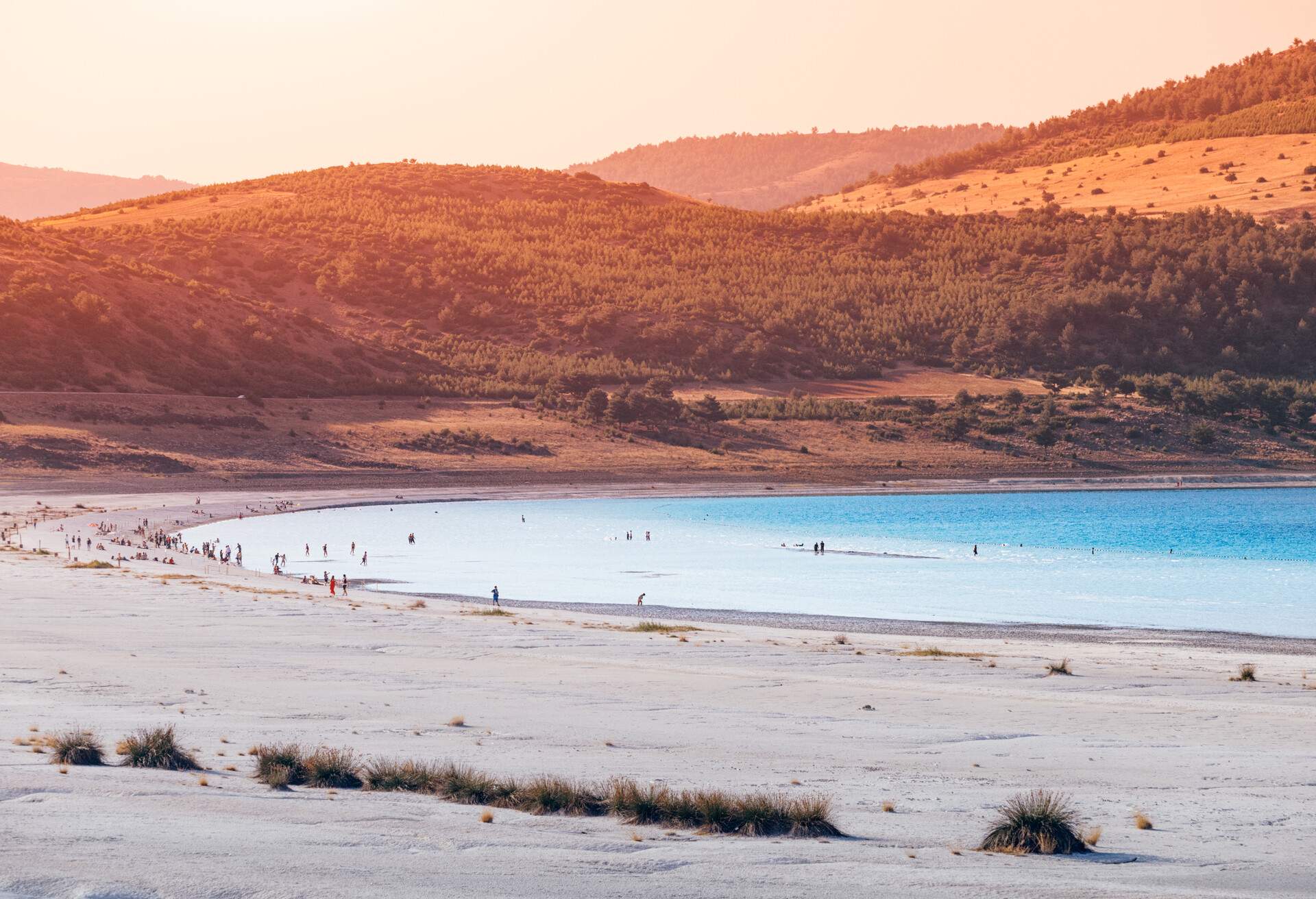 Narrow zoom view of the white sandy beach with grass bushes on the famous lake Salda in Turkey. Wonders of nature and turkish maldives concept