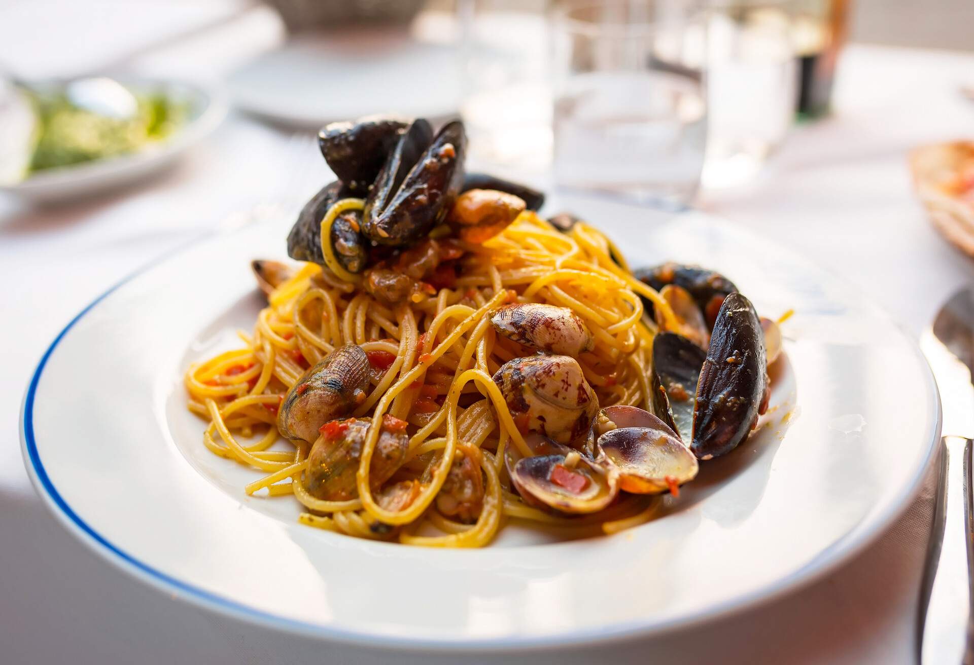 Italian pasta with seafood and herbs on the restaurant table