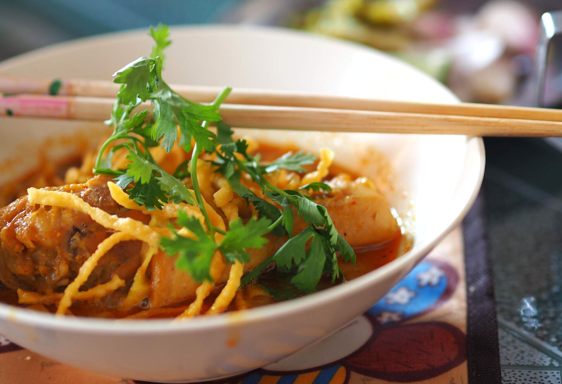 Khao Soi Gai or Northern Thai Coconut Curry Noodle Soup With Chicken with chopsticks.