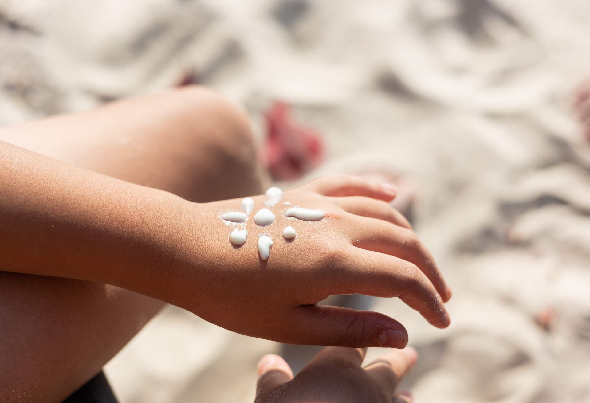 Boy with sun shaped sunscreen on his hand