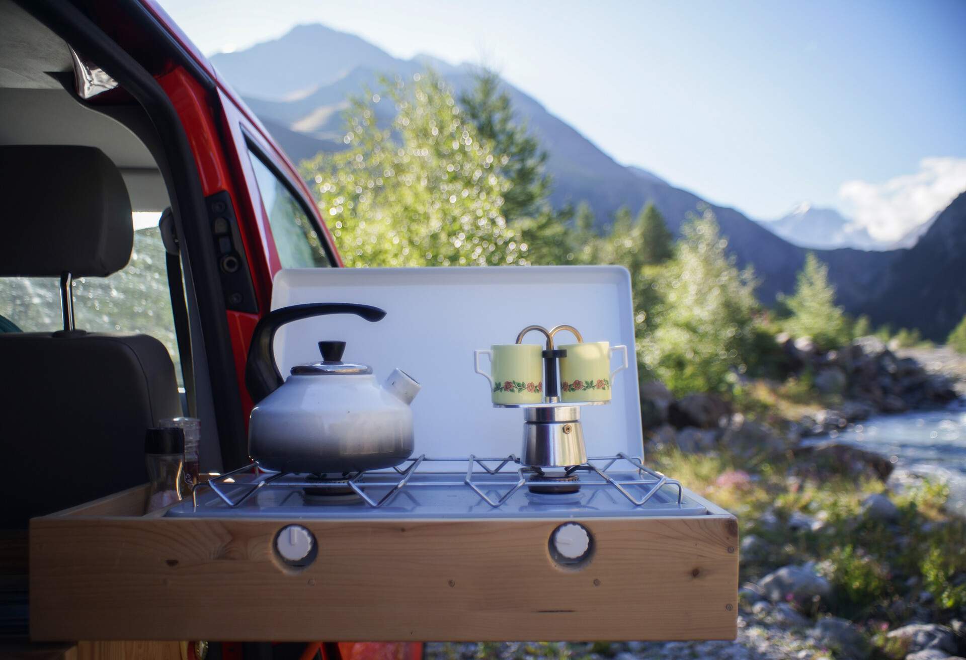 Van life at it's best: Making coffee in the middle of nowhere with the amazing view of the French Alps. A nice feature of this campervan: you can slide the gas stove outside!