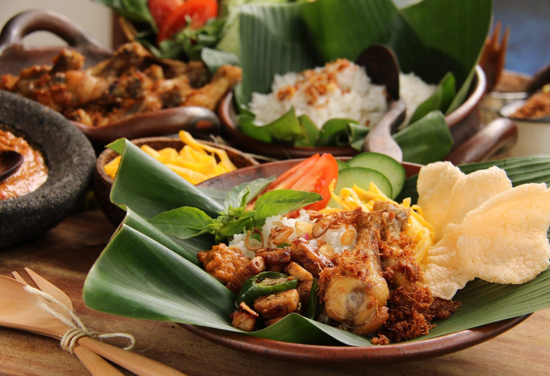 Nasi Uduk Betawi. Coconut flavored steamed rice dish from Betawi, Jakarta. Served with fried chicken, sauteed tempeh, omelet, cracker crisps, fresh vegetables and spicy peanut sauce.; Shutterstock ID 494293957