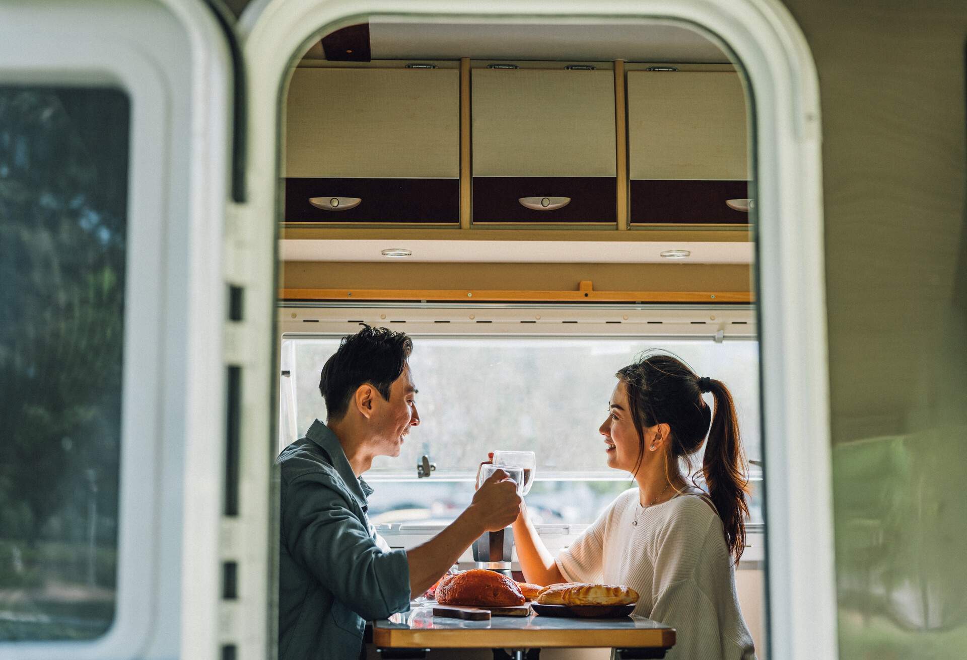 Lovely Asian Chinese couple enjoy their breakfast and coffee at the camper