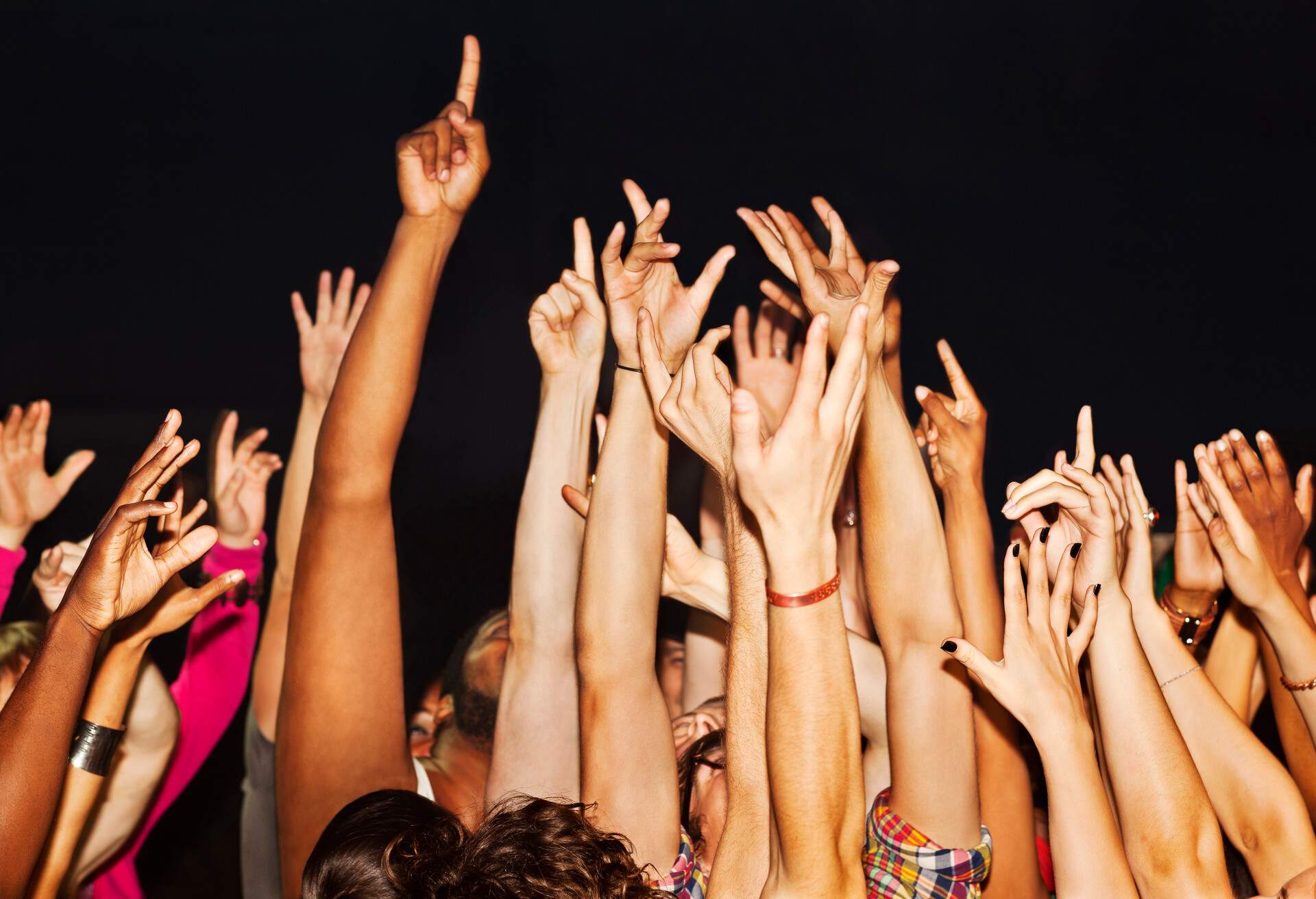 Large crowd with hands and fingers pointing up, excited