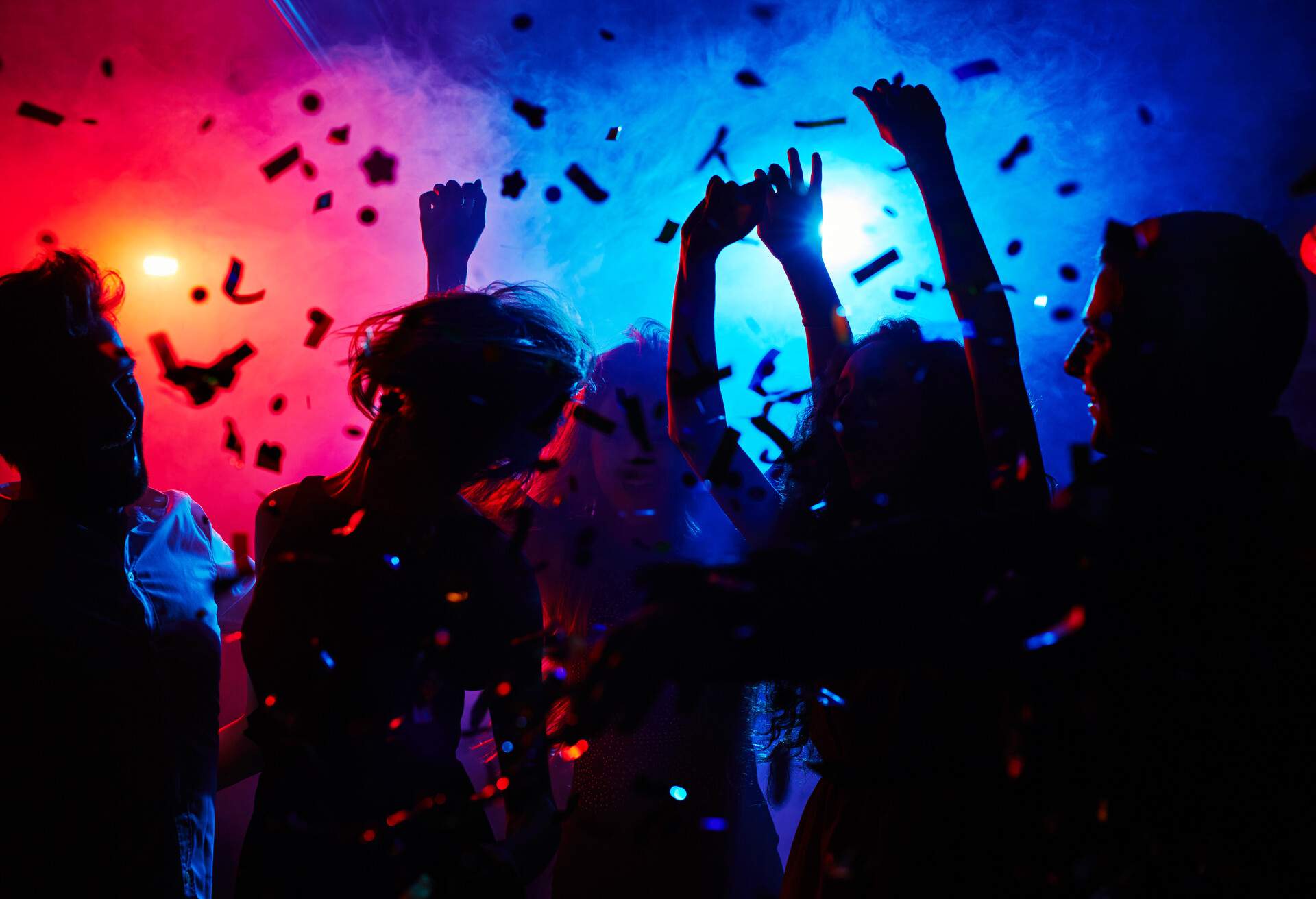 Silhouettes of dancers moving in confetti