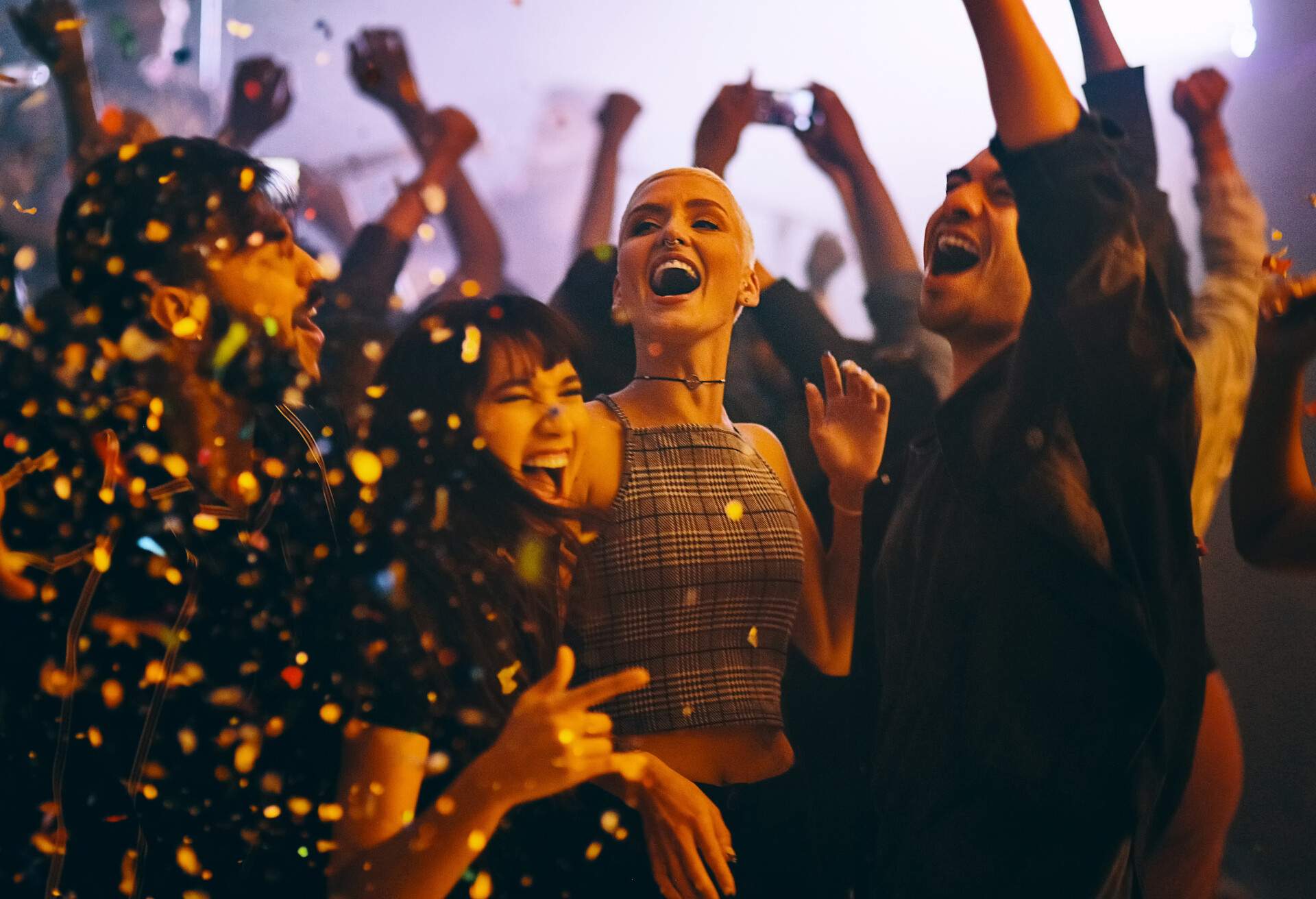 Cropped shot of a group of energetic young friends dancing at a party in a nightclub