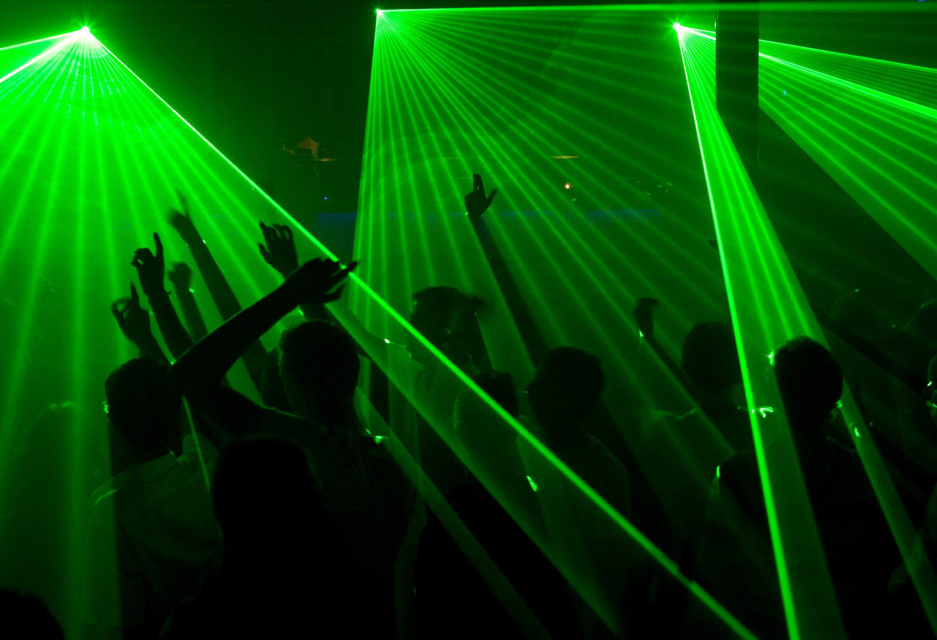 Students dancing in a night club with a laser show in their freshman introduction week.