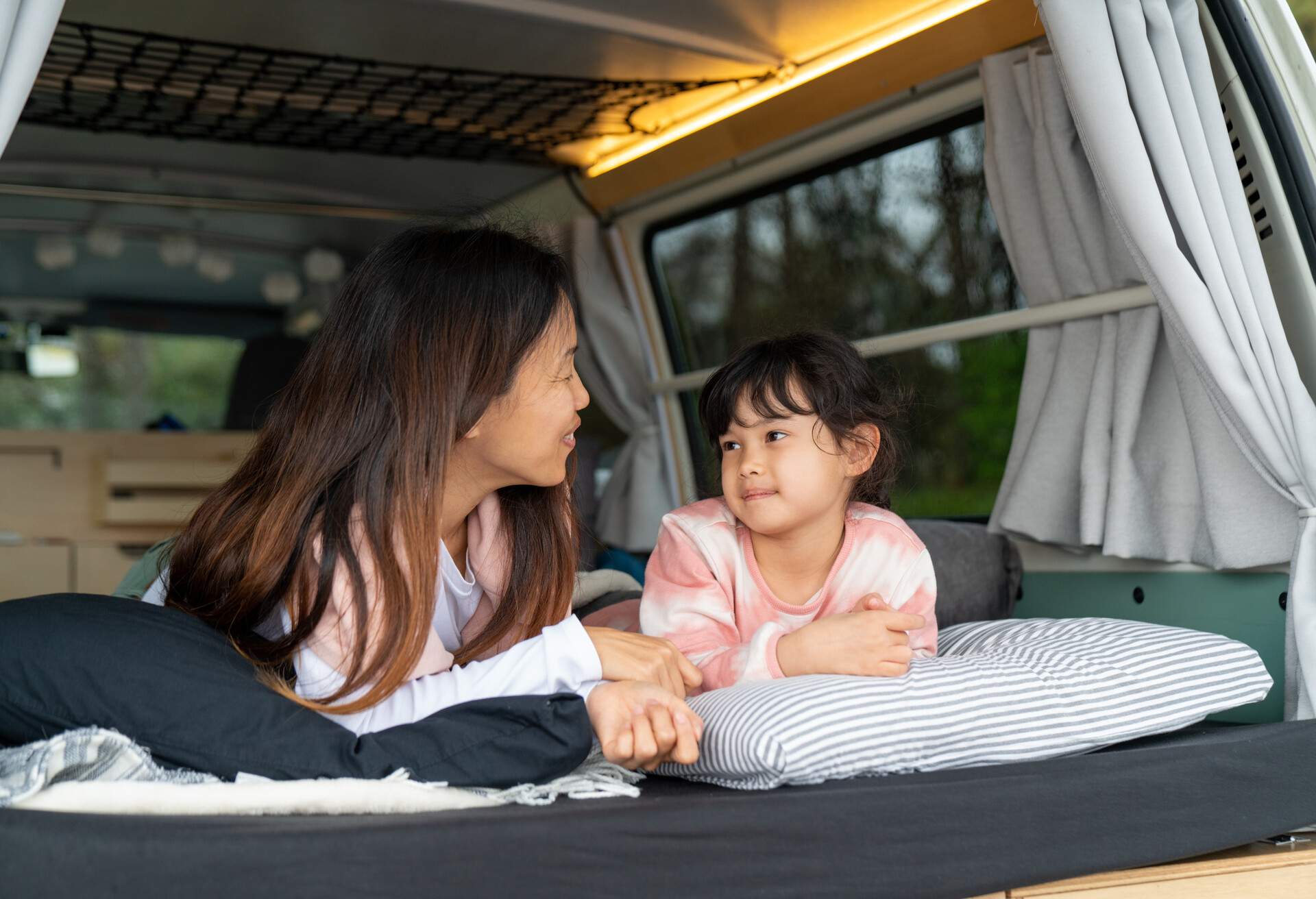 Mother and daughter relaxing in a camper van. Wakayama, Japan