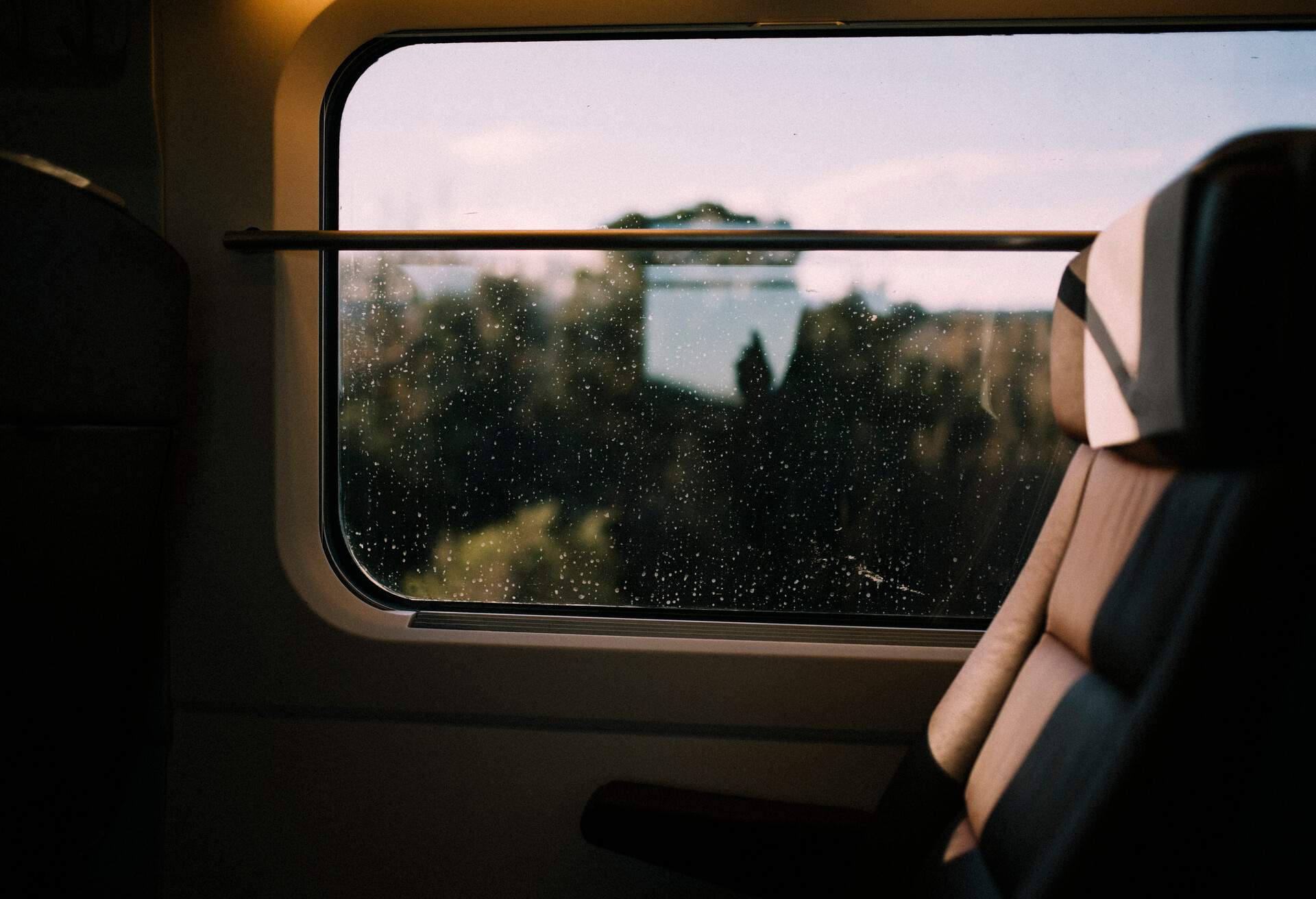 Window train views with rain and light reflects with blue sky, taken in Spain