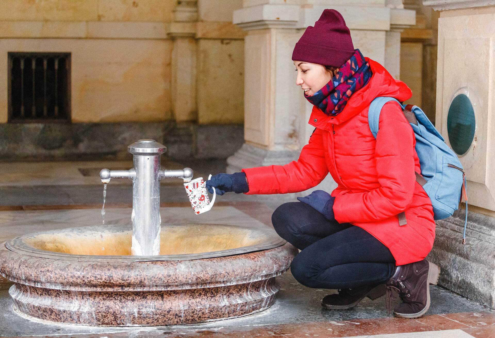 A tourist woman drinks water from a medicinal thermal spring in Karlovy Vary, Czech Republic