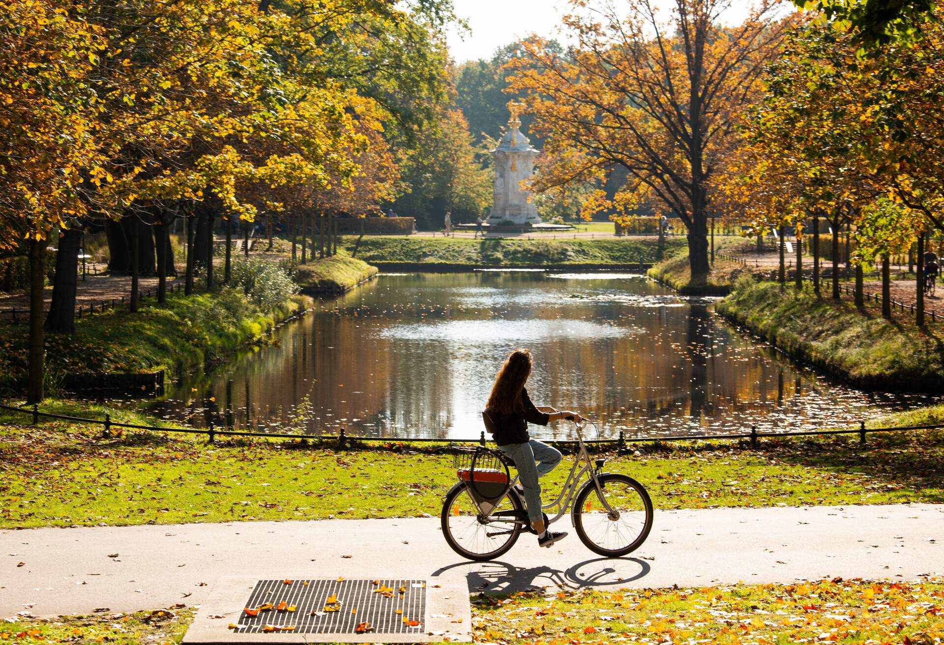 A female cyclist rides a bicycle in the Tiergarten park in Berlin; Shutterstock ID 1148951849