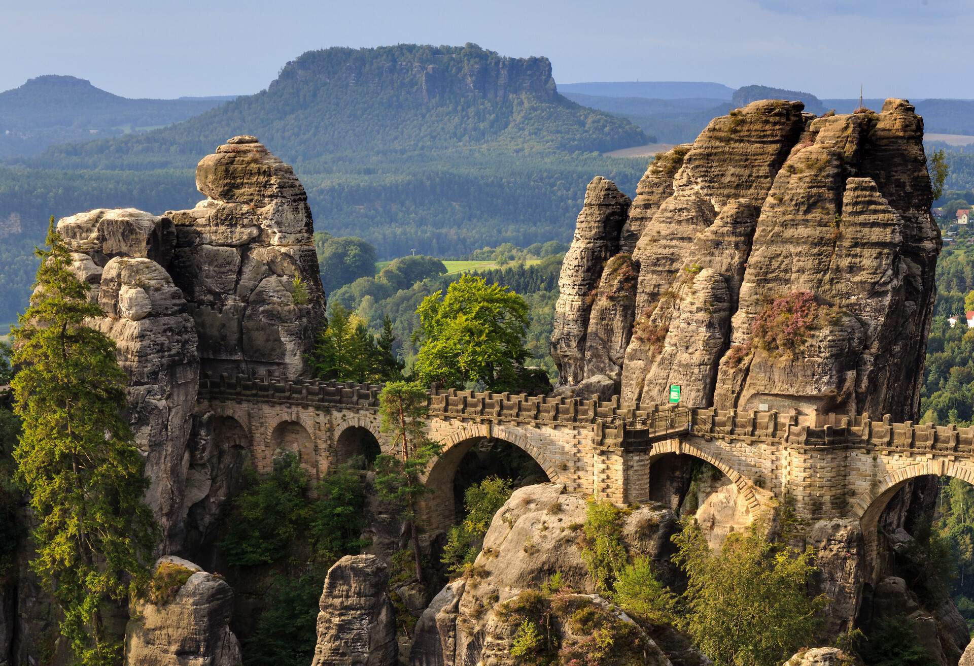 Famous Bastion Bridge in the Saxonian Swiss in Germany, shot on a warm summer morning after sunrise. Amazing Landmark of Saxonia. Impressive Sandstone Rock Formations. Bridge leading to a former medieval castle near Dresden