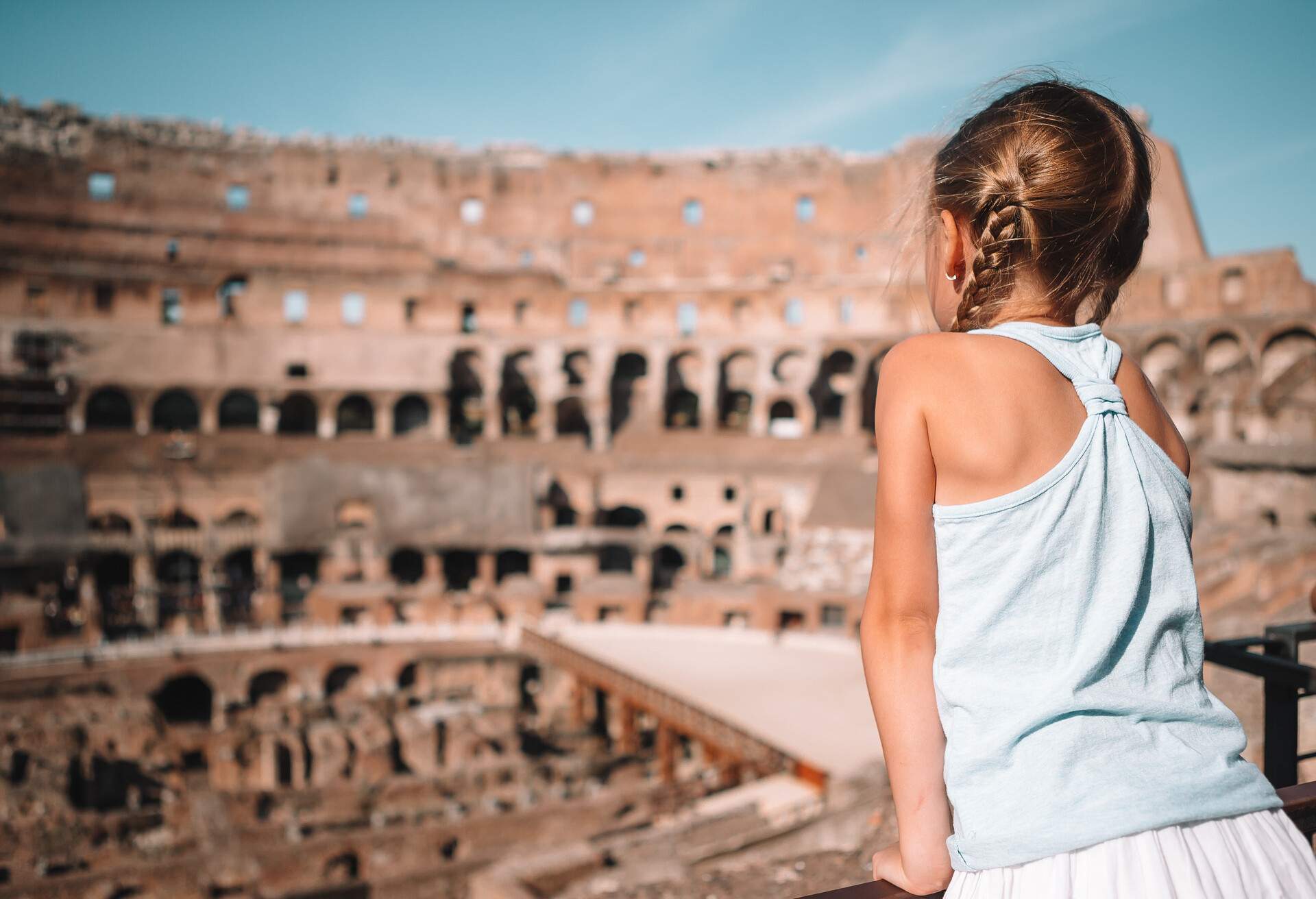 Little girl in Coliseum, Rome, Italy. Back view of kid looking at famous places in Europe