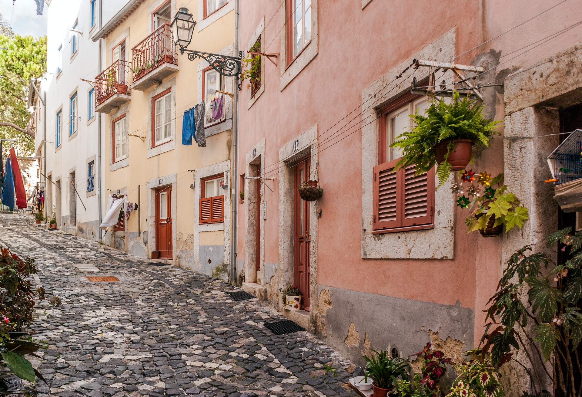 Typical narrow street and cobblestone floor of Alfama district in Lisbon, capital of Portugal