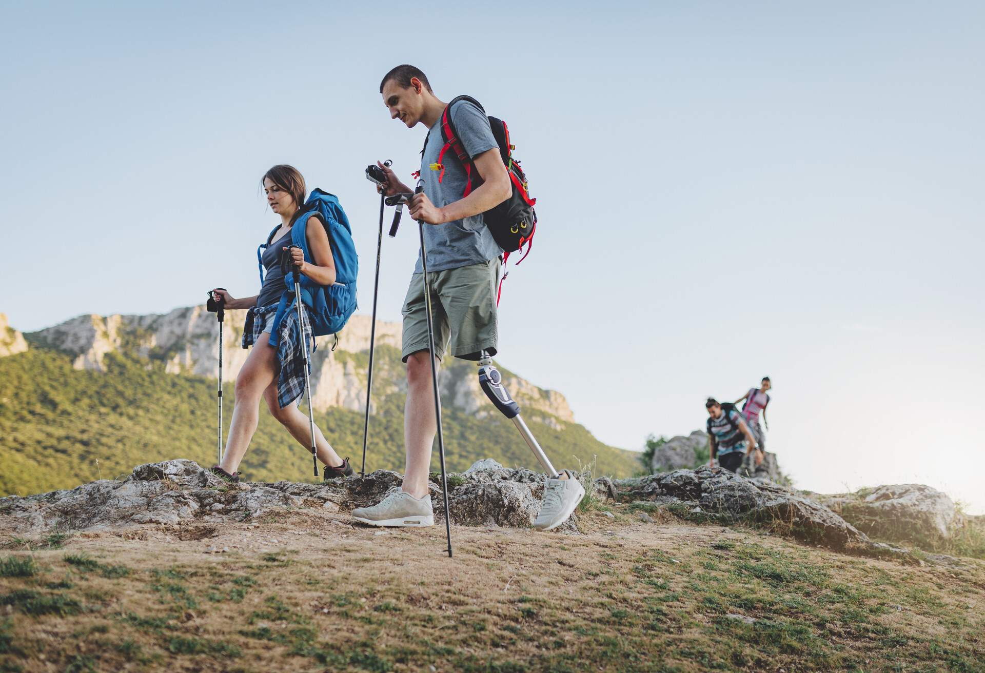 A group of people hiking the mountains, living the healthy lifestyle, with an amputee friend.