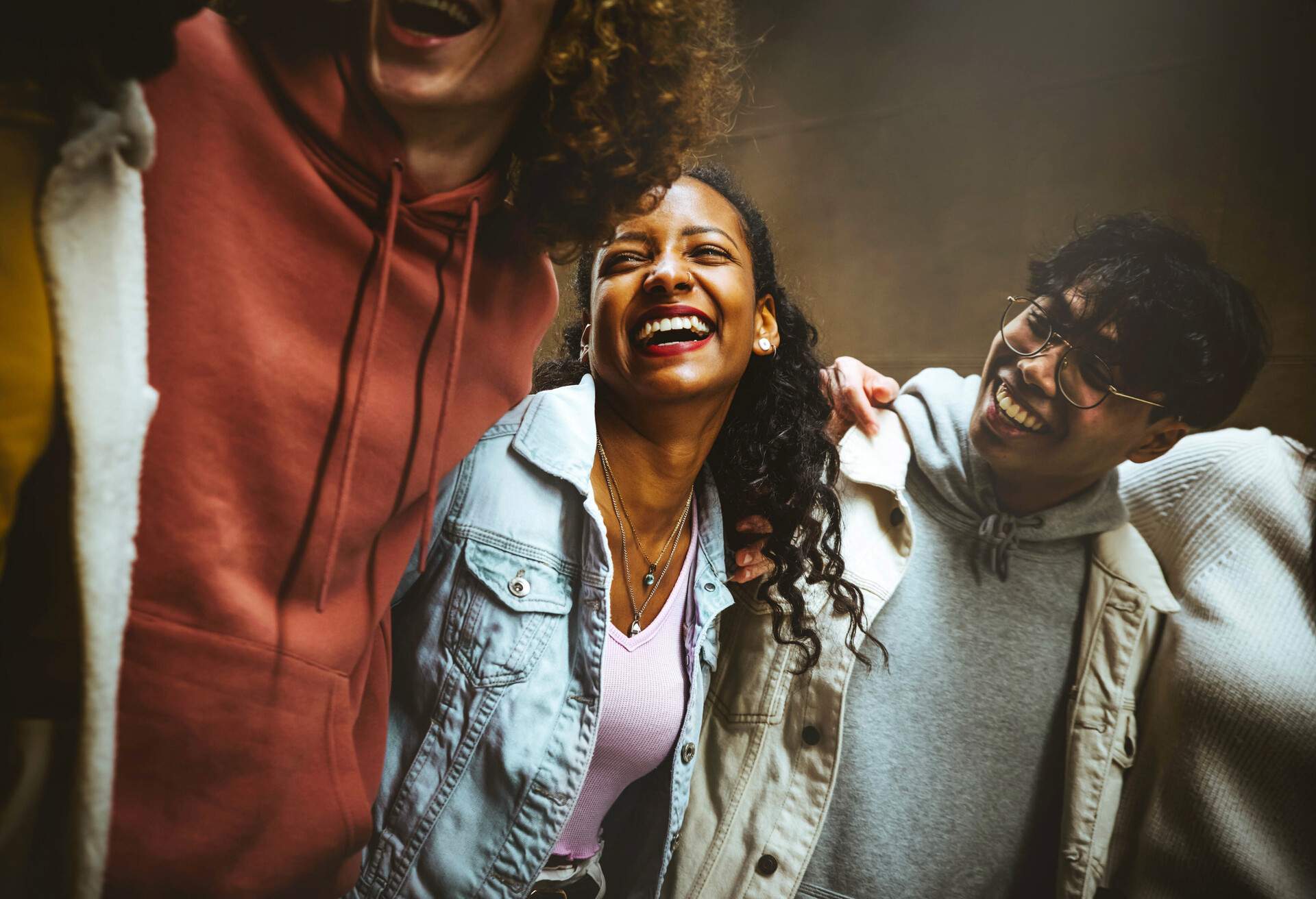 Happy young people laughing together - Multiracial friends group having fun on city street - Mixed race students hanging out together -Friendship, community, youth, university concept