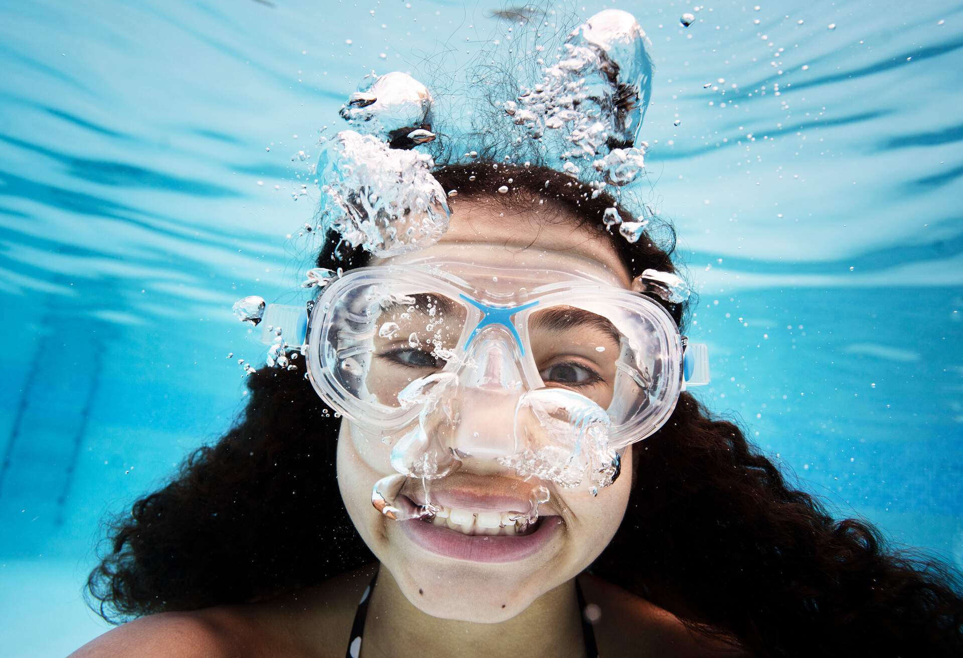 Young girl 14 yrs old, in swimming pool, swimming towards camera