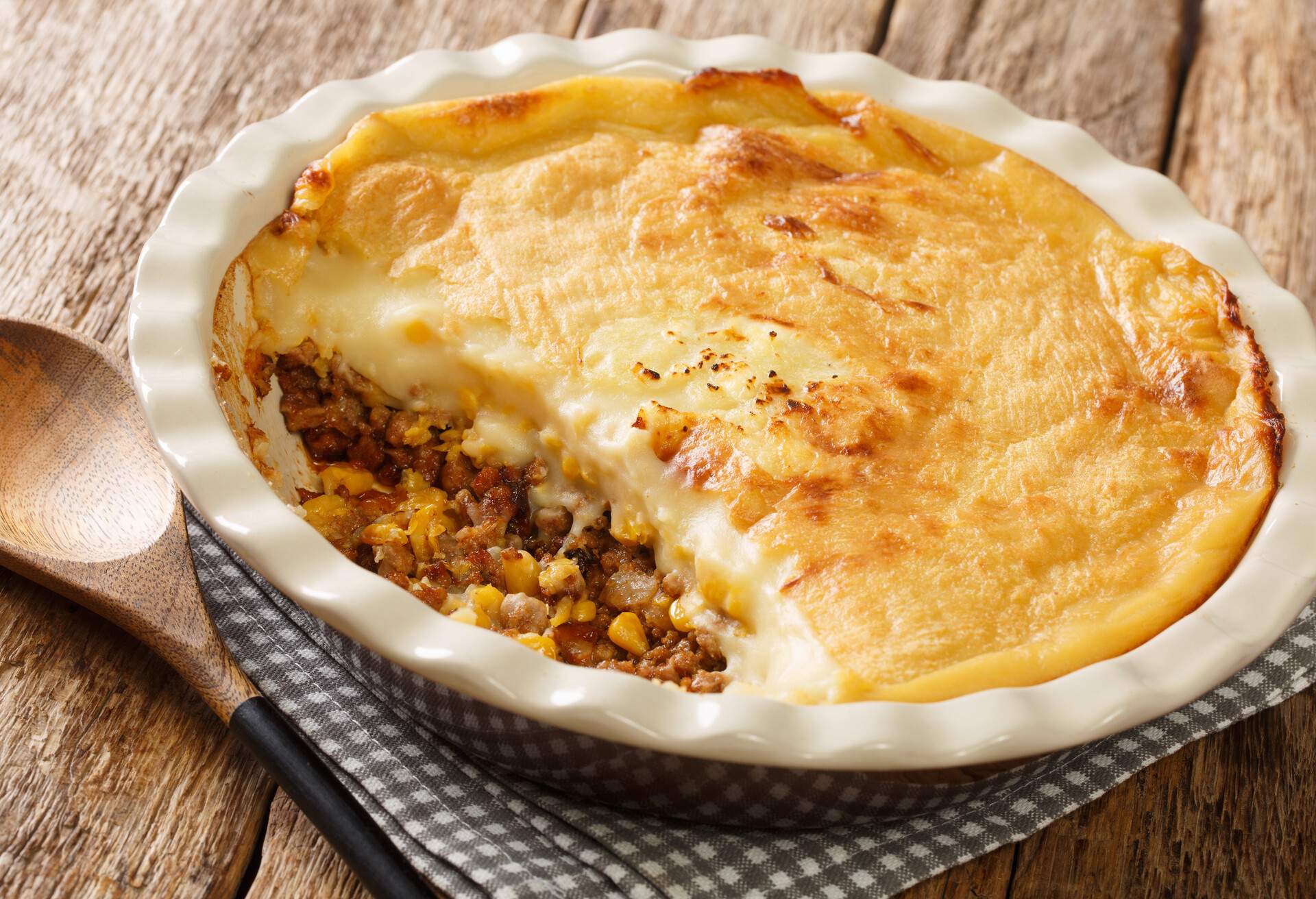 French Canadian Pate Pie Chinois made of ground beef, corn and mashed potatoes closeup in the baking dish on the table. Horizontal