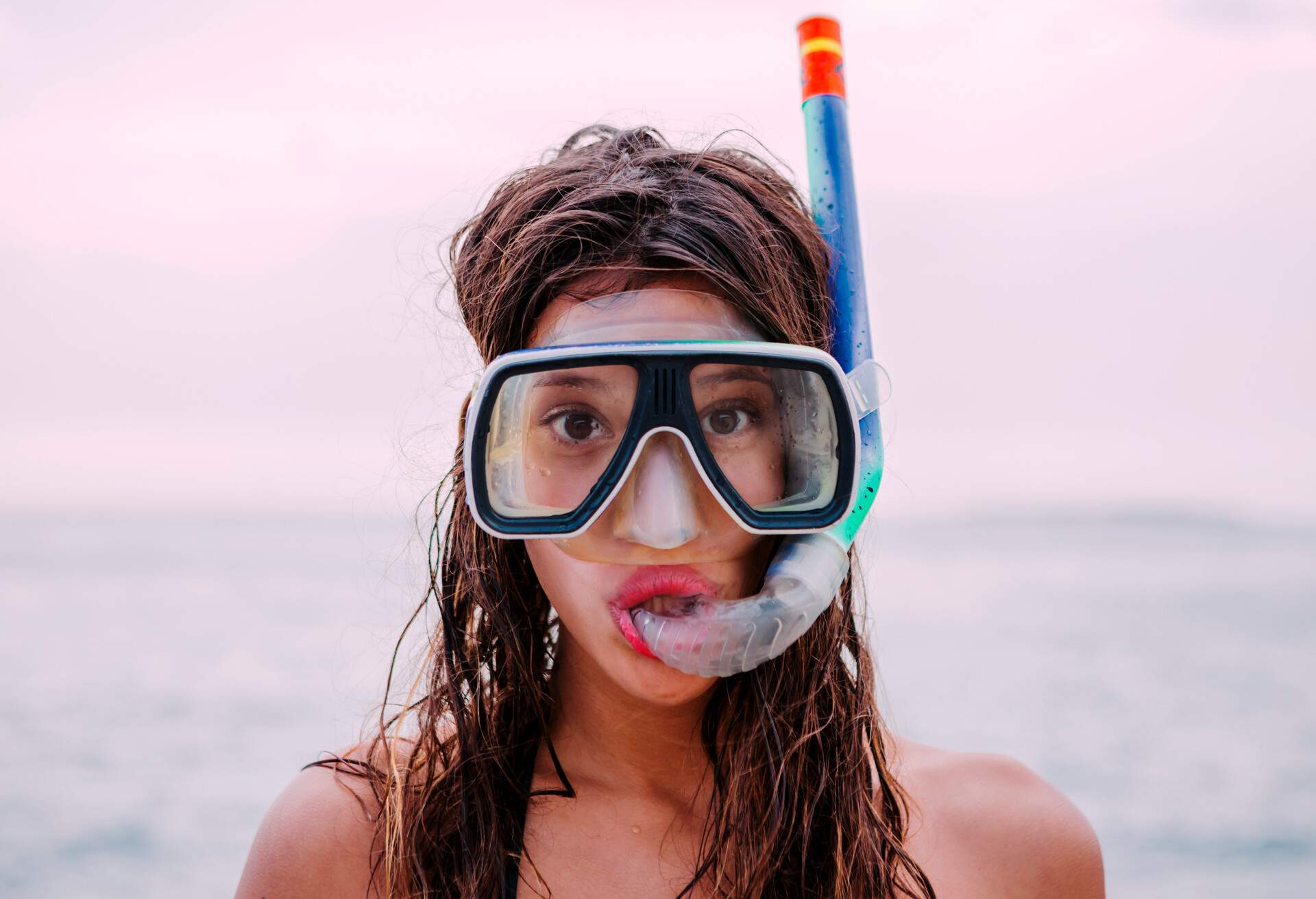 portrait of woman on beach wearing snorkel and mask