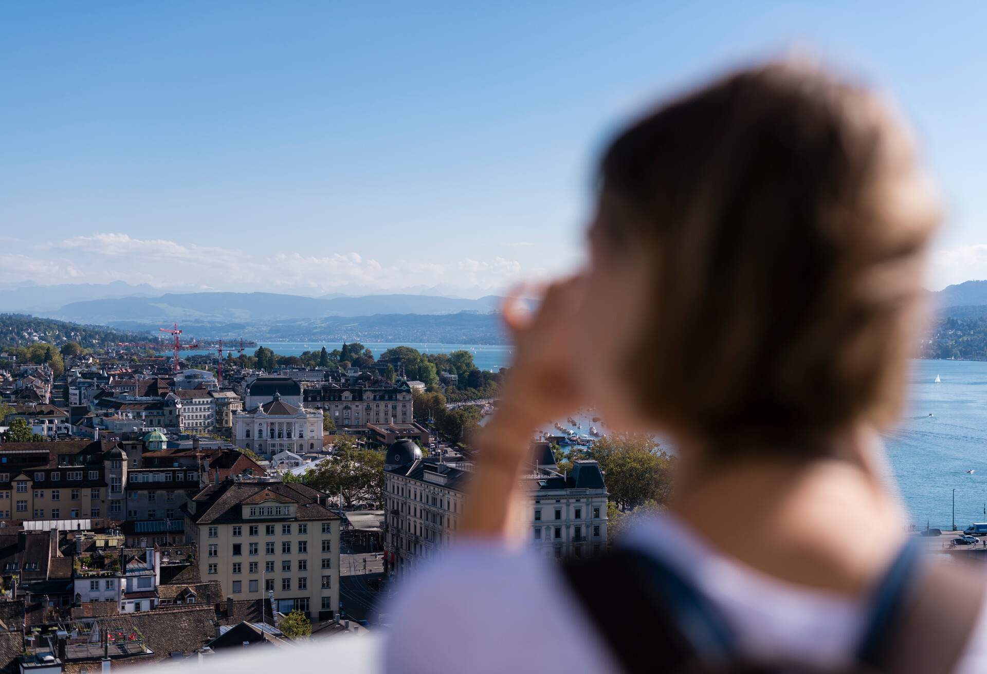 Zurich, Switzerland - 30 September 2016: A female tourist is taking pictures of Zurich from the observation deck on top of Grossmunster cathedral.