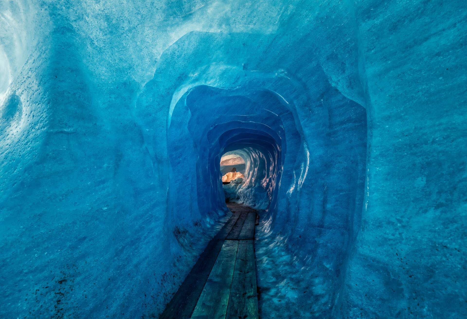 blue ice inside a cave under melting rhone glacier, switzerland