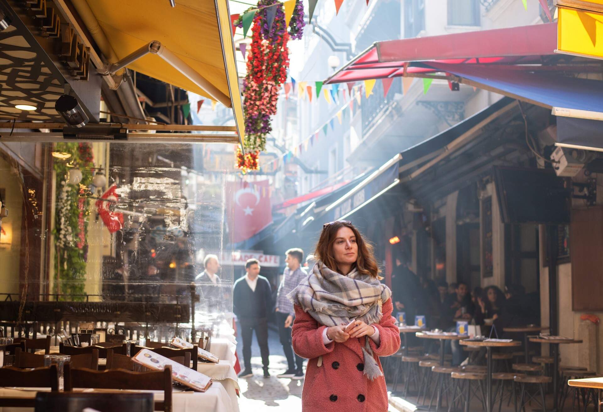 A mid adult woman in winter clothes exploring Istanbul's various landmarks.