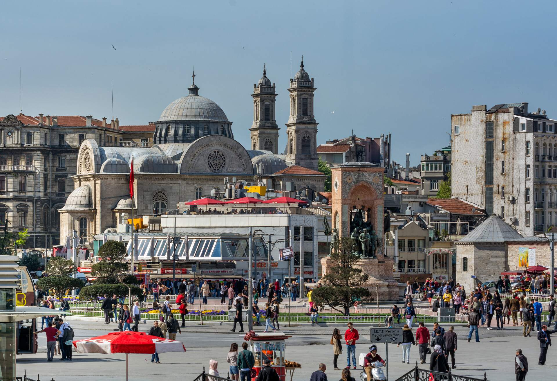 Taksim Square is the most known modern city center of Istanbul.The Independence Monument and Hagia Triada Greek Orthodox Church in the backround.