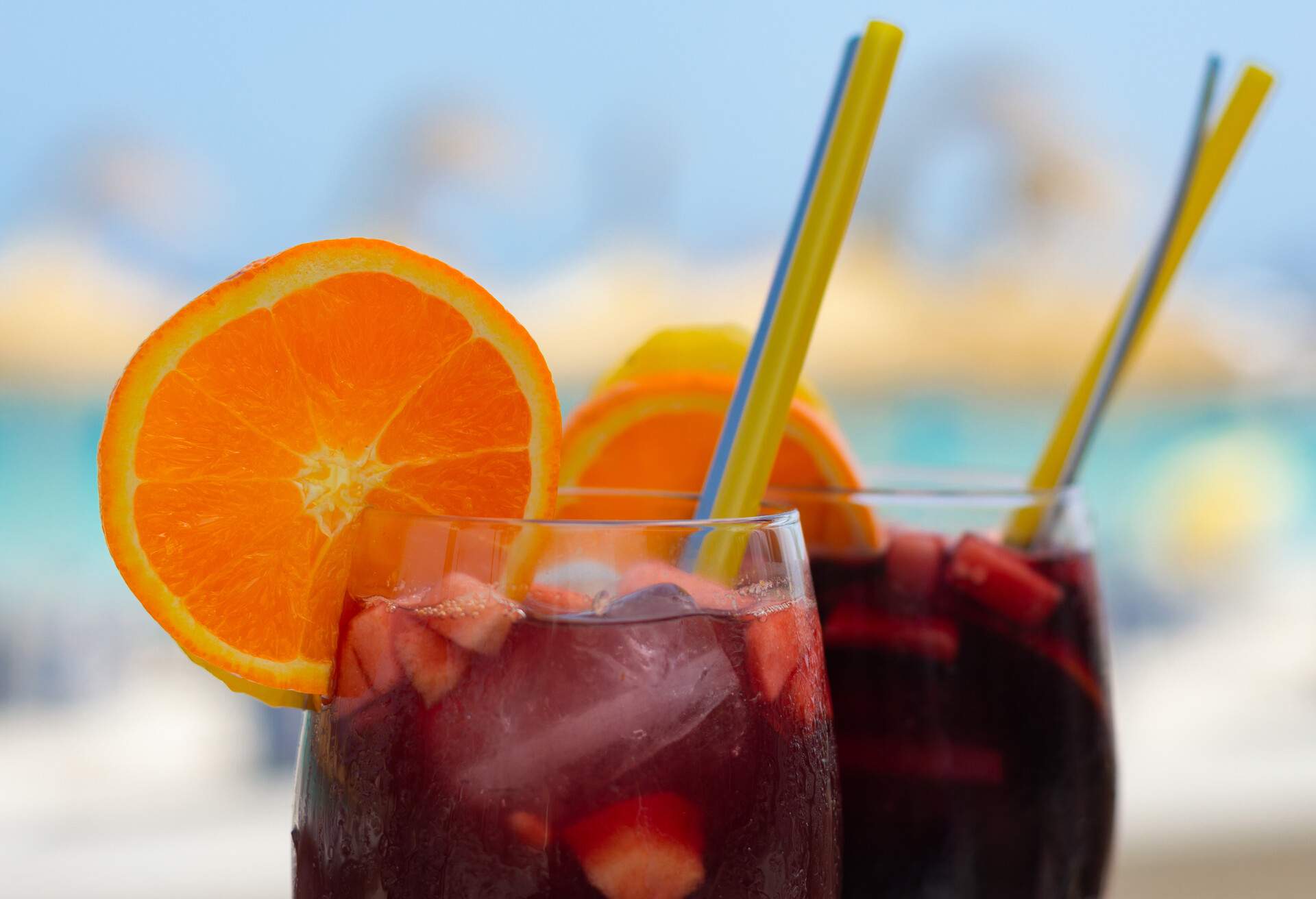 close up to two delicious glasses of sangria, a drink of red wine and a slice of orange.