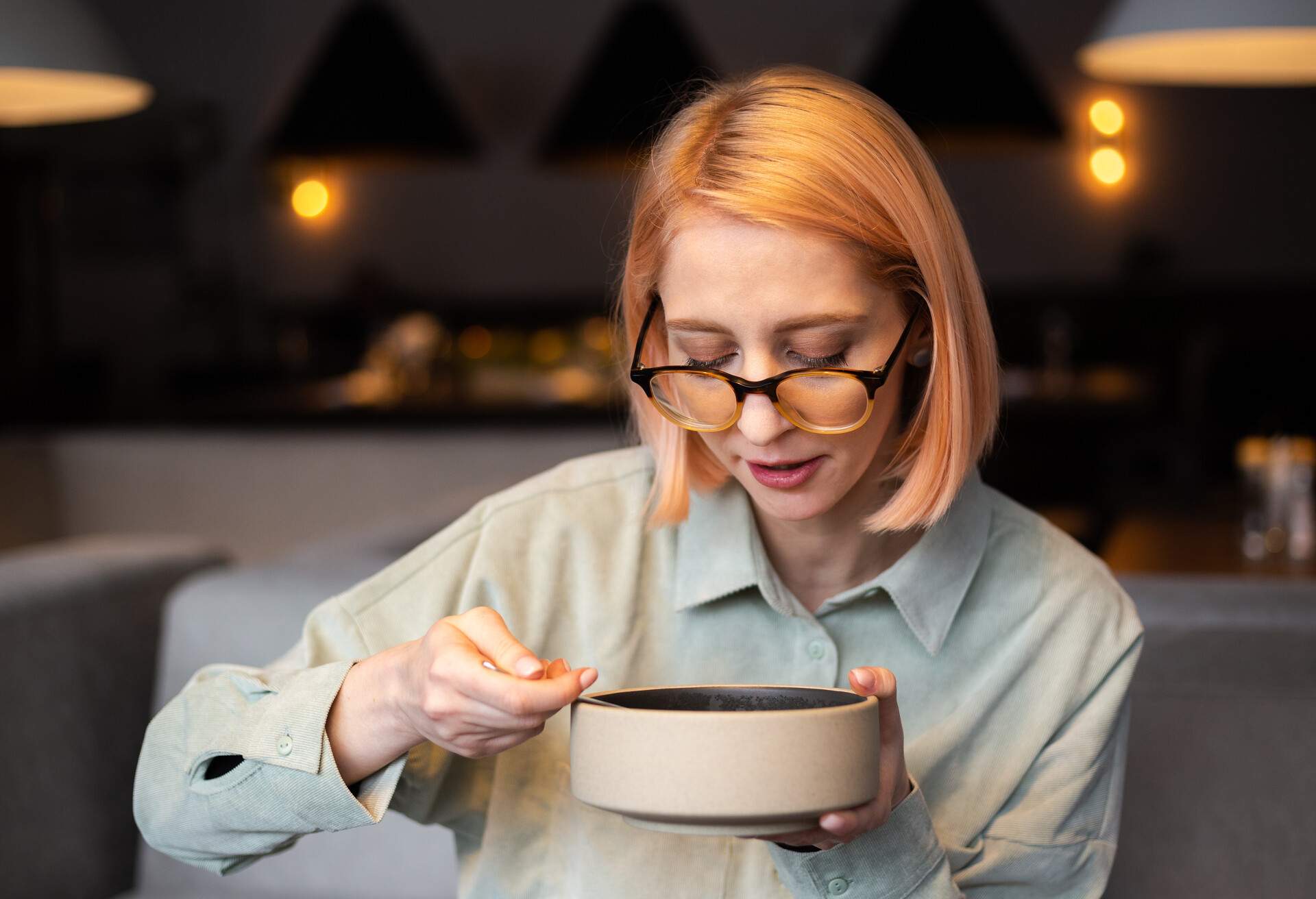 WOMAN is EATING SOUP at the RESTAURANT