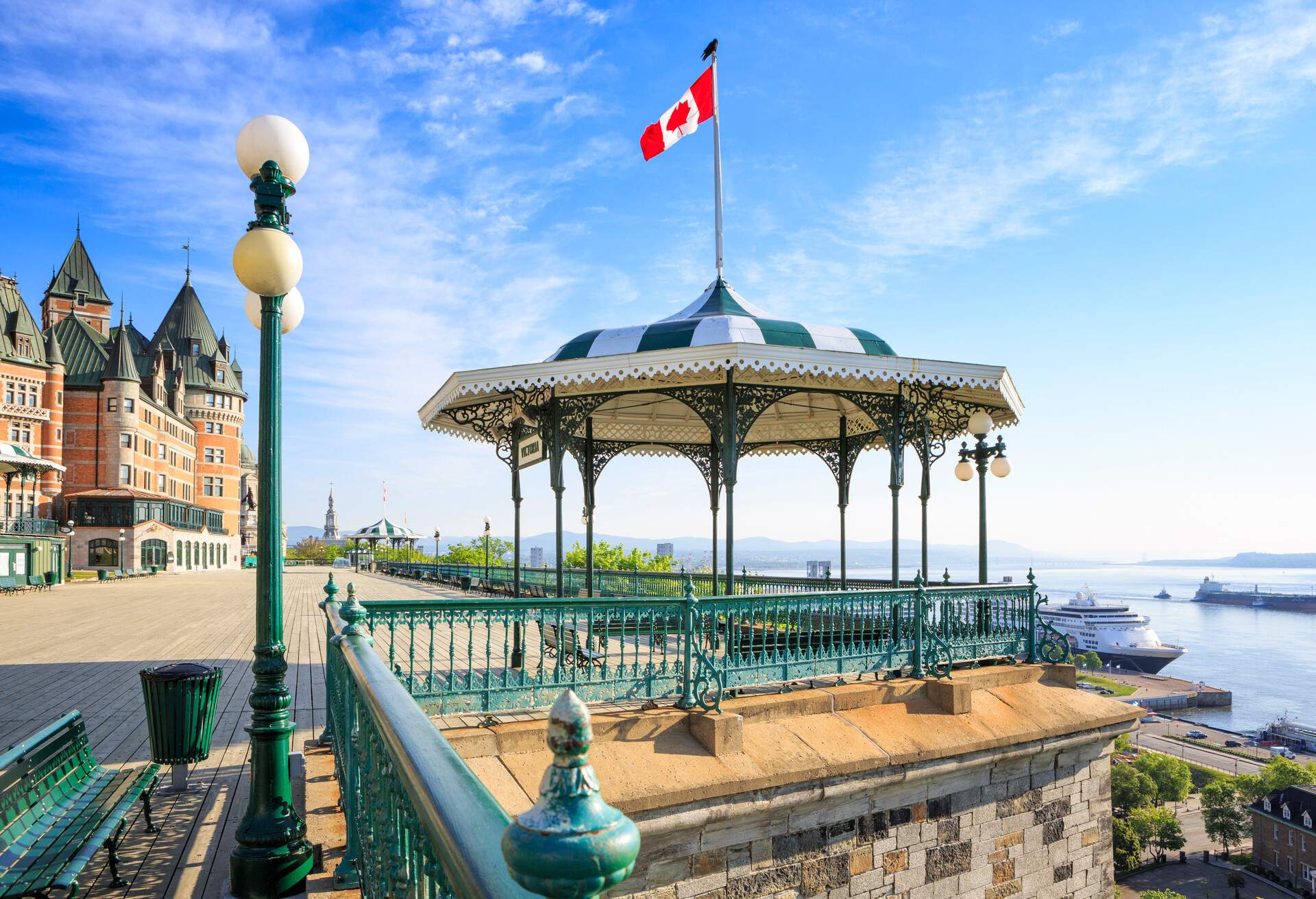 Quebec City, Canada. Early morning shot of Terrasse Dufferin with the Hotel Chateau Frontenac in the background to the left. No people present. A cruise ship at the pier below at Saint Lawrence river.