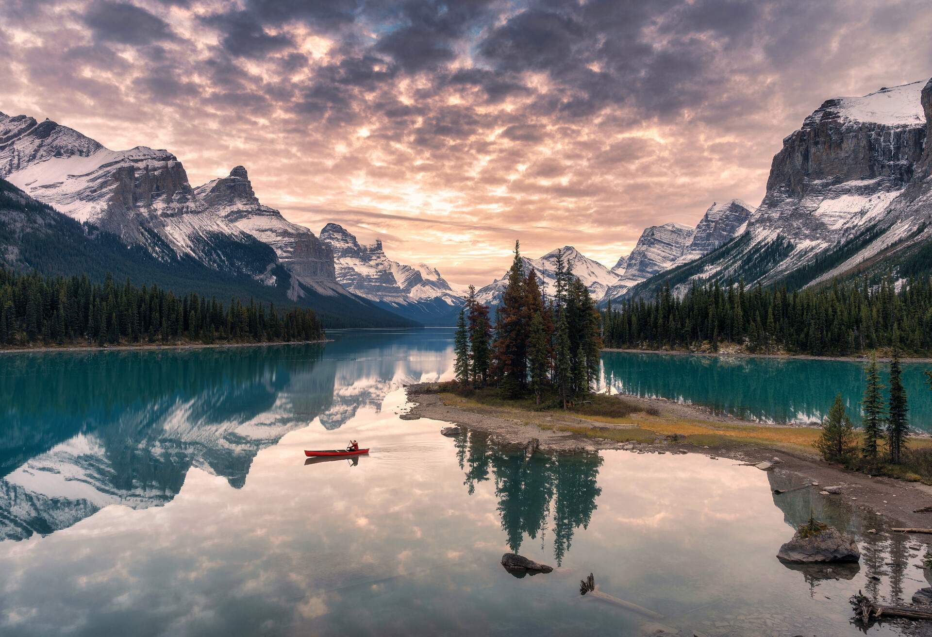 Traveler canoeing with rocky mountain reflection on Maligne lake at Spirit island in Jasper national park, Canada